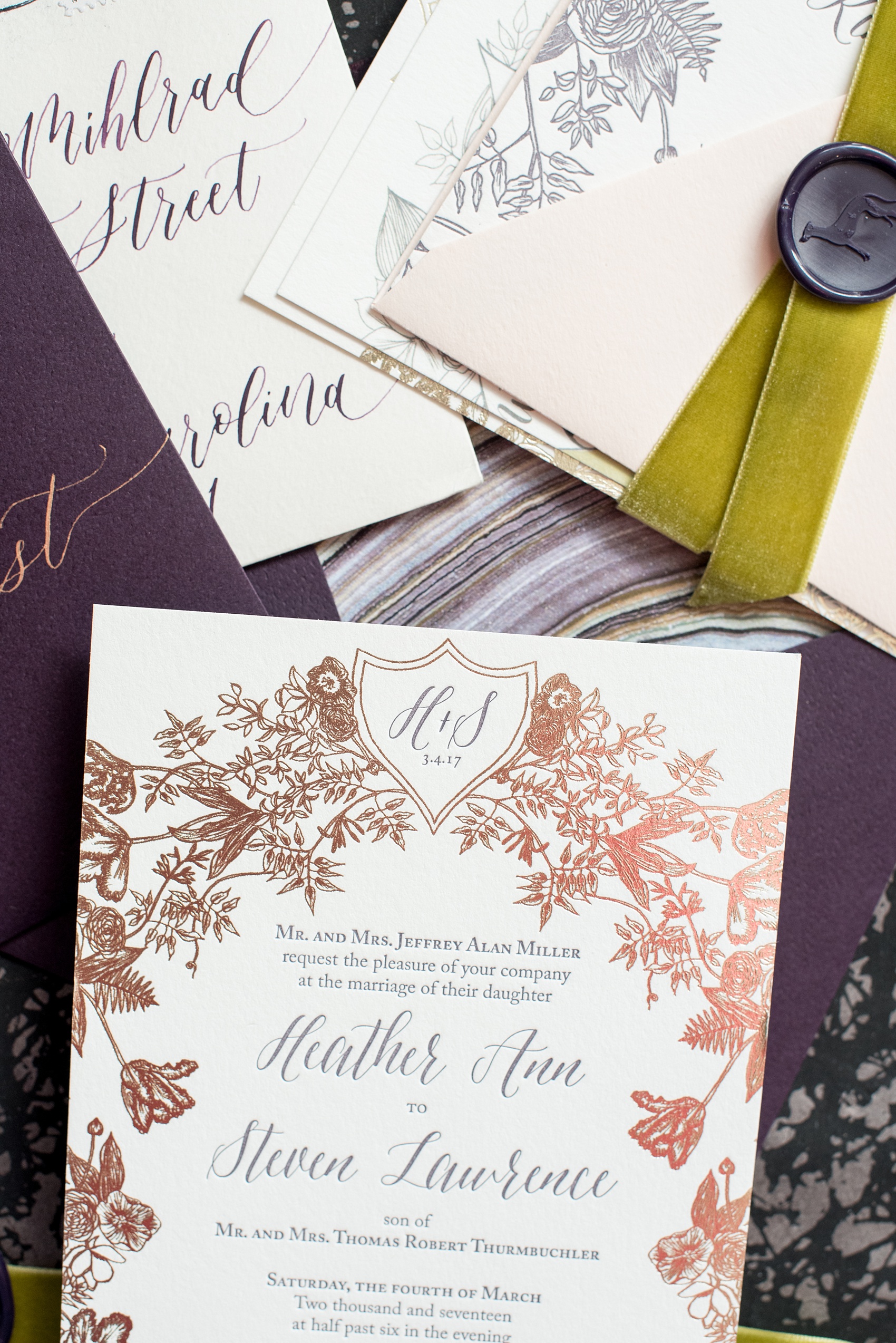 Mikkel Paige Photography image of a wedding invitation suite in purple, grey and copper by One and Only Paper. Calligraphy by Quietude Co in Raleigh, NC. Velvet yellow-green chartreuse ribbon and custom wax seals with the couples greyhound dog were included. The envelope liner was agate gem marble inspired.