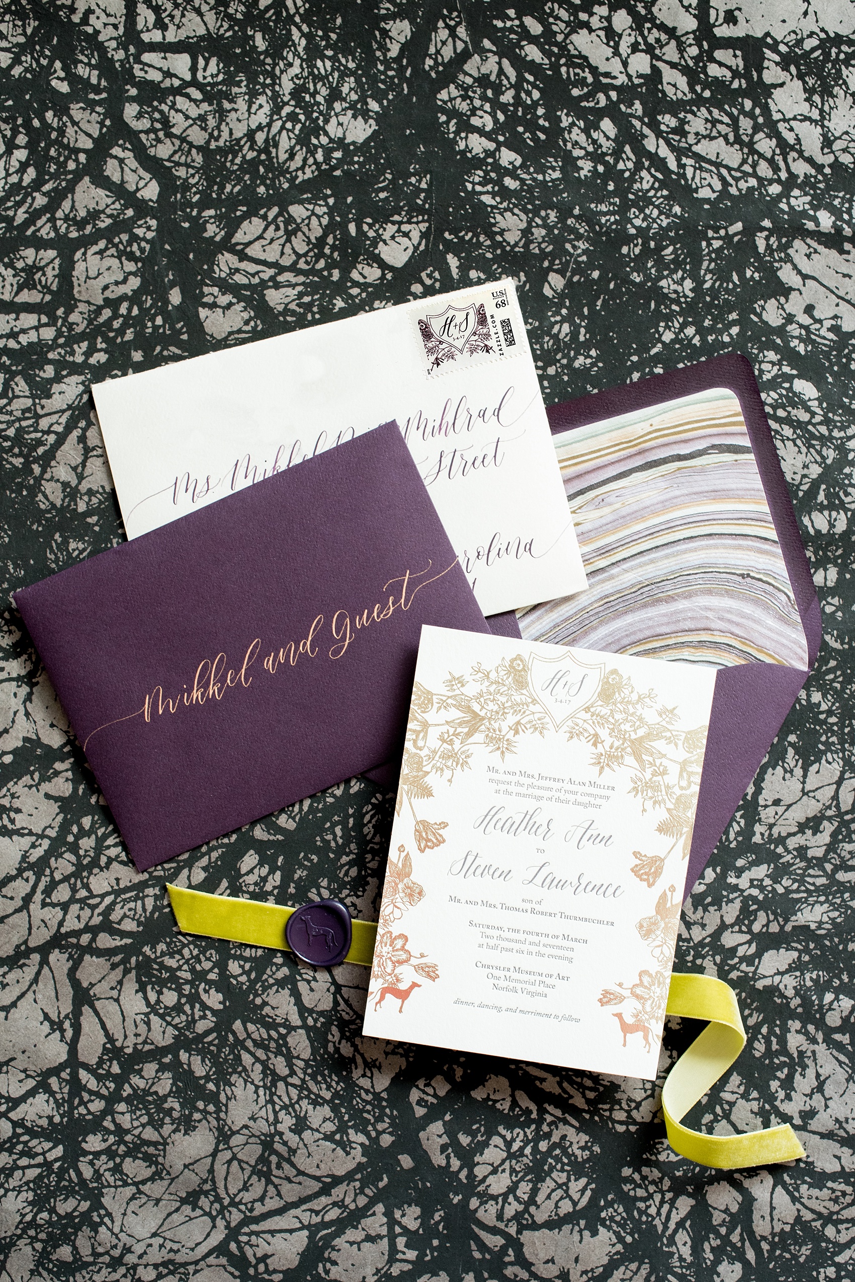 Mikkel Paige Photography image of a wedding invitation suite in purple, grey and copper by One and Only Paper. Calligraphy by Quietude Co in Raleigh, NC. Velvet yellow-green chartreuse ribbon and custom wax seals with the couples greyhound dog were included. The envelope liner was agate gem marble inspired.