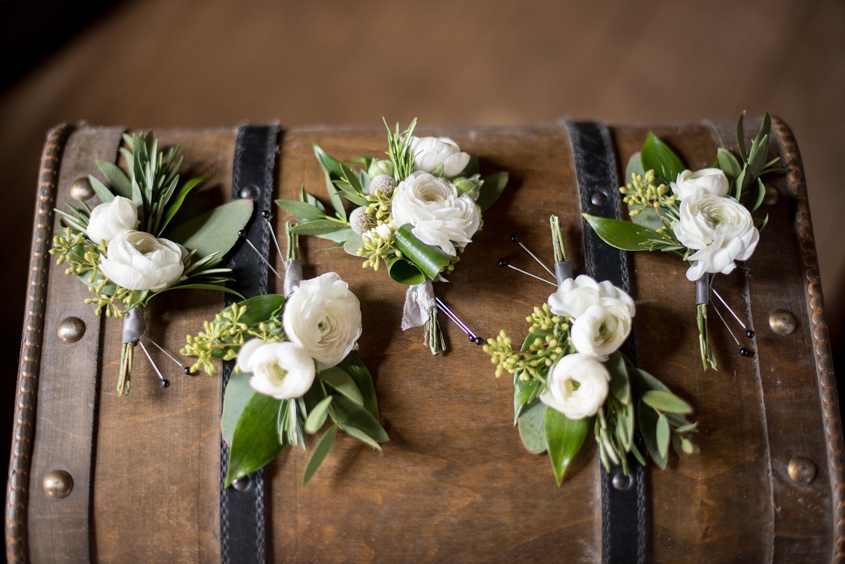 The Sutherland Wedding Photos by Mikkel Paige Photography. Detail picture of white and green ranunculus and eucalyptus boutonnieres by Eclectic Sage. Planning by A Southern Soiree.