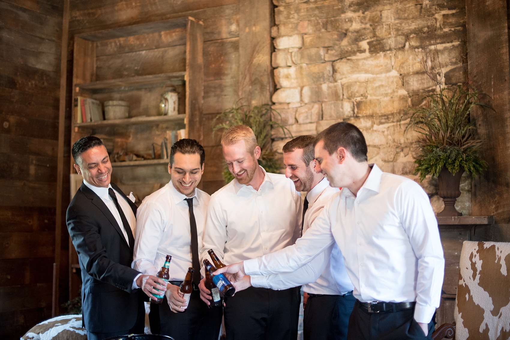 The Sutherland Wedding Photos by Mikkel Paige Photography. Picture of the groomsmen getting ready in a rustic wooden cabin.