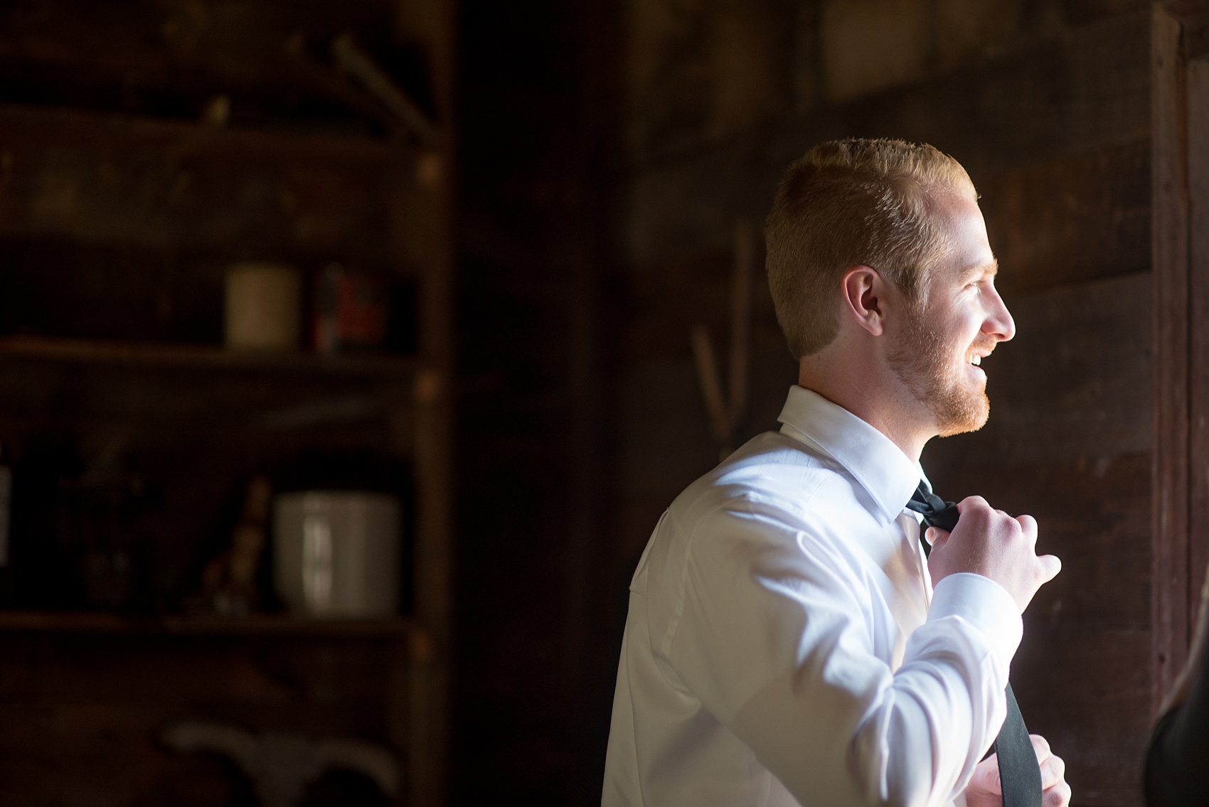 The Sutherland Wedding Photos by Mikkel Paige Photography. Picture of the groom getting ready in a rustic cabin. Planning by A Southern Soiree.