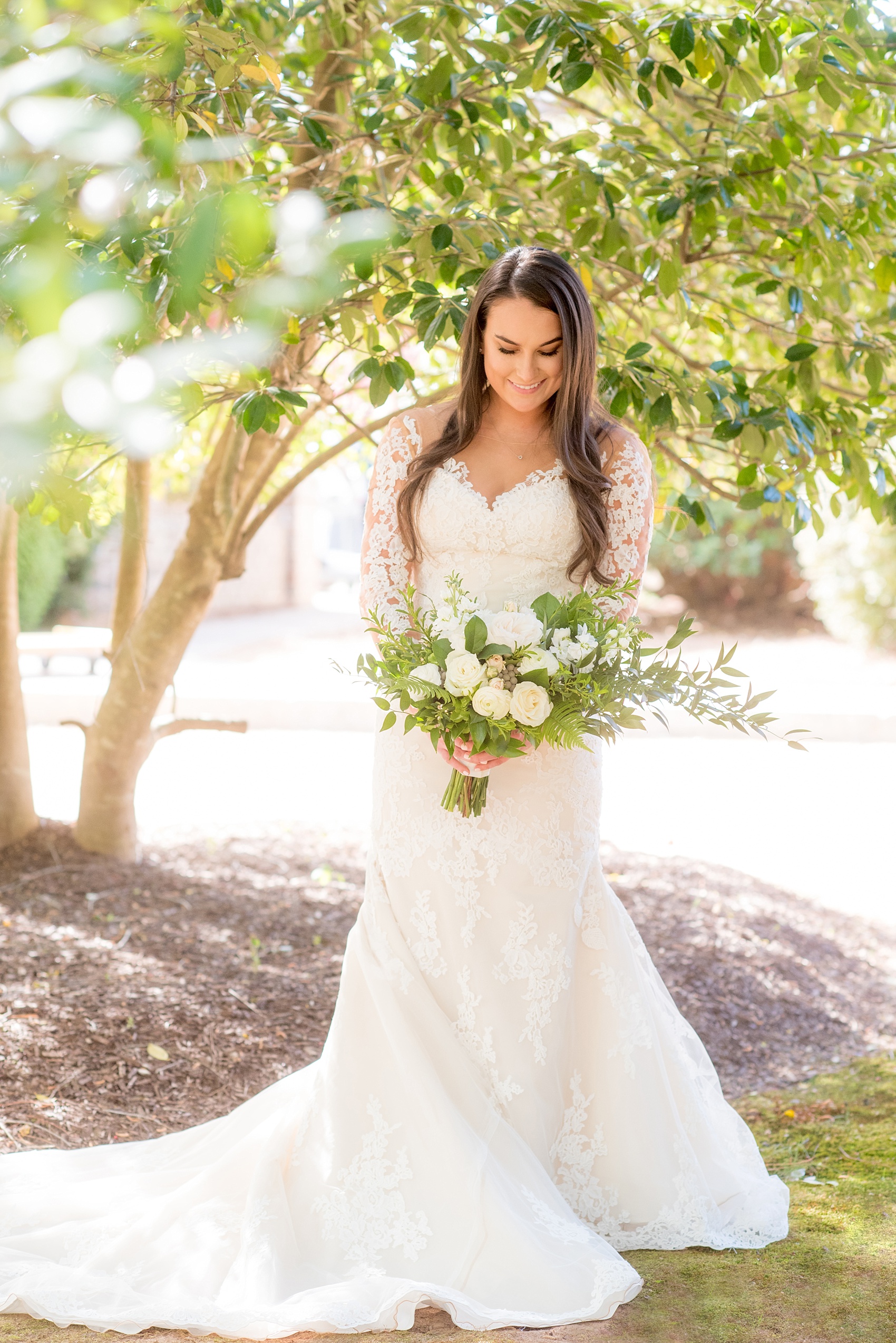 The Sutherland Wedding Photos by Mikkel Paige Photography. Picture of the bride in her long-sleeve, illusion neck, lace Pronovias gown with green and white bouquet by Eclectic Sage. Planning by A Southern Soiree.