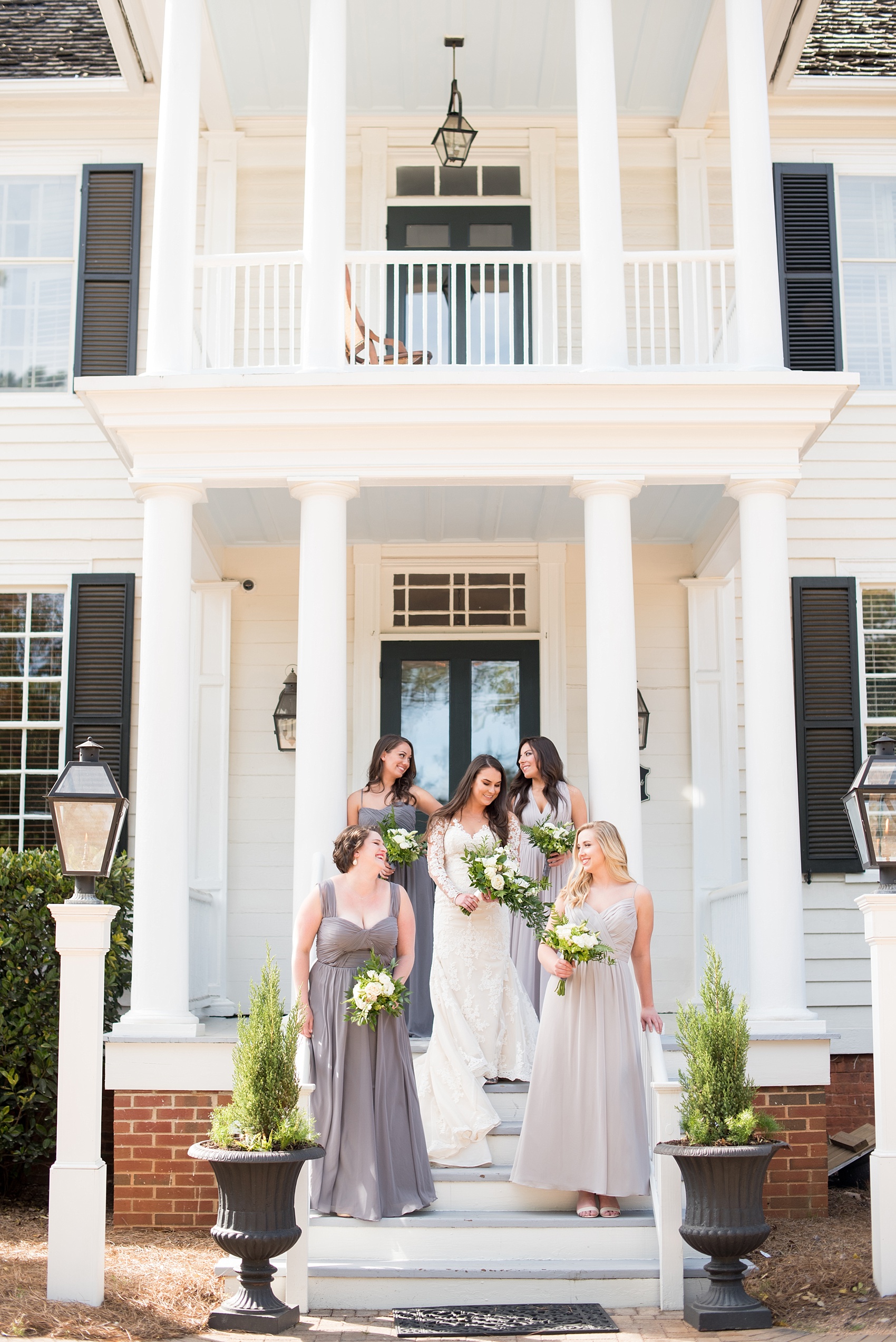 The Sutherland Wedding Photos by Mikkel Paige Photography. Vogue-like bridal party picture with the bride in lace Pronovias and bridesmaids party in various shades of grey gowns. Planning by A Southern Soiree.