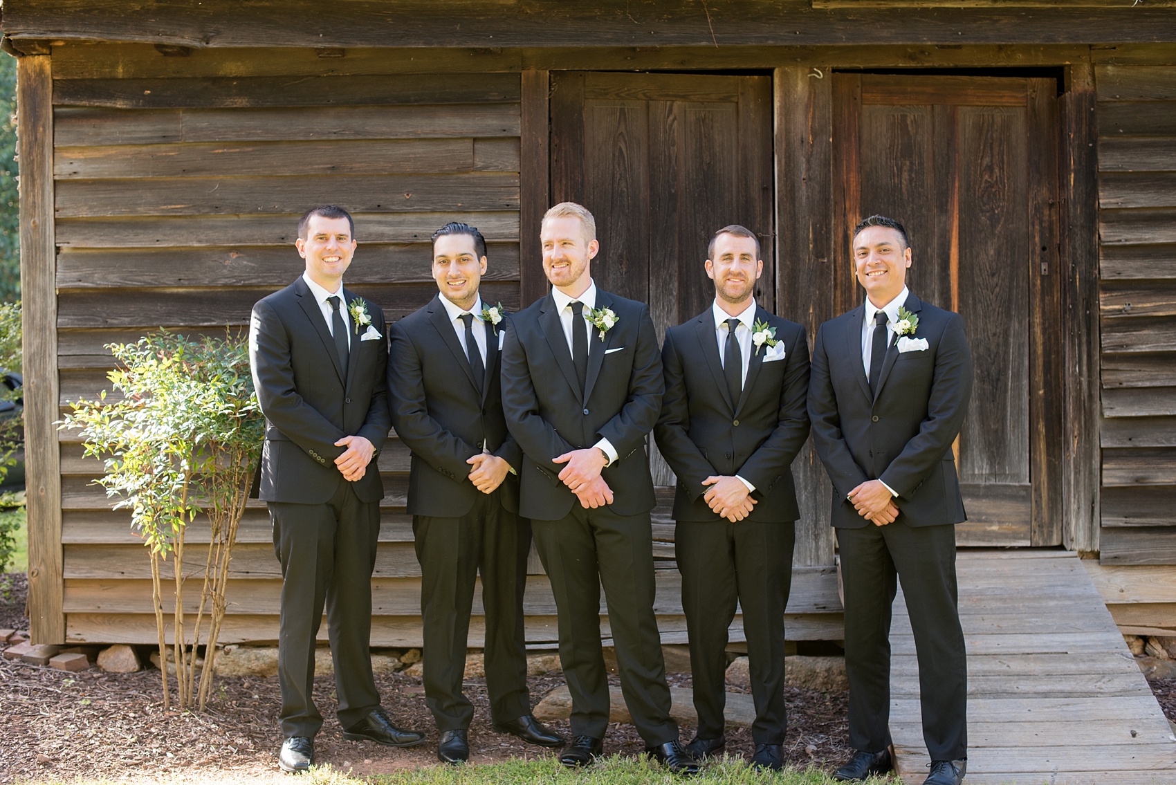 The Sutherland Wedding Photos by Mikkel Paige Photography. A fun groomsmen candid picture with the wedding party in classic black suits.