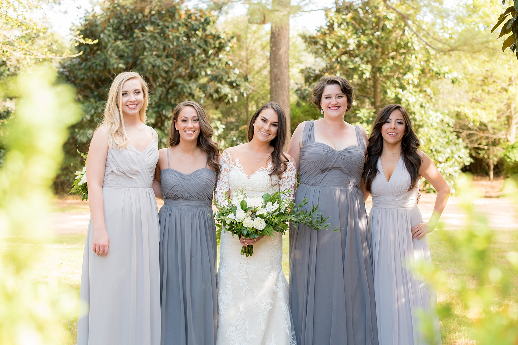 The Sutherland Wedding Photos by Mikkel Paige Photography. Bridal party picture with the bride in lace Pronovias and bridesmaids party in various shades of grey gowns. Planning by A Southern Soiree.