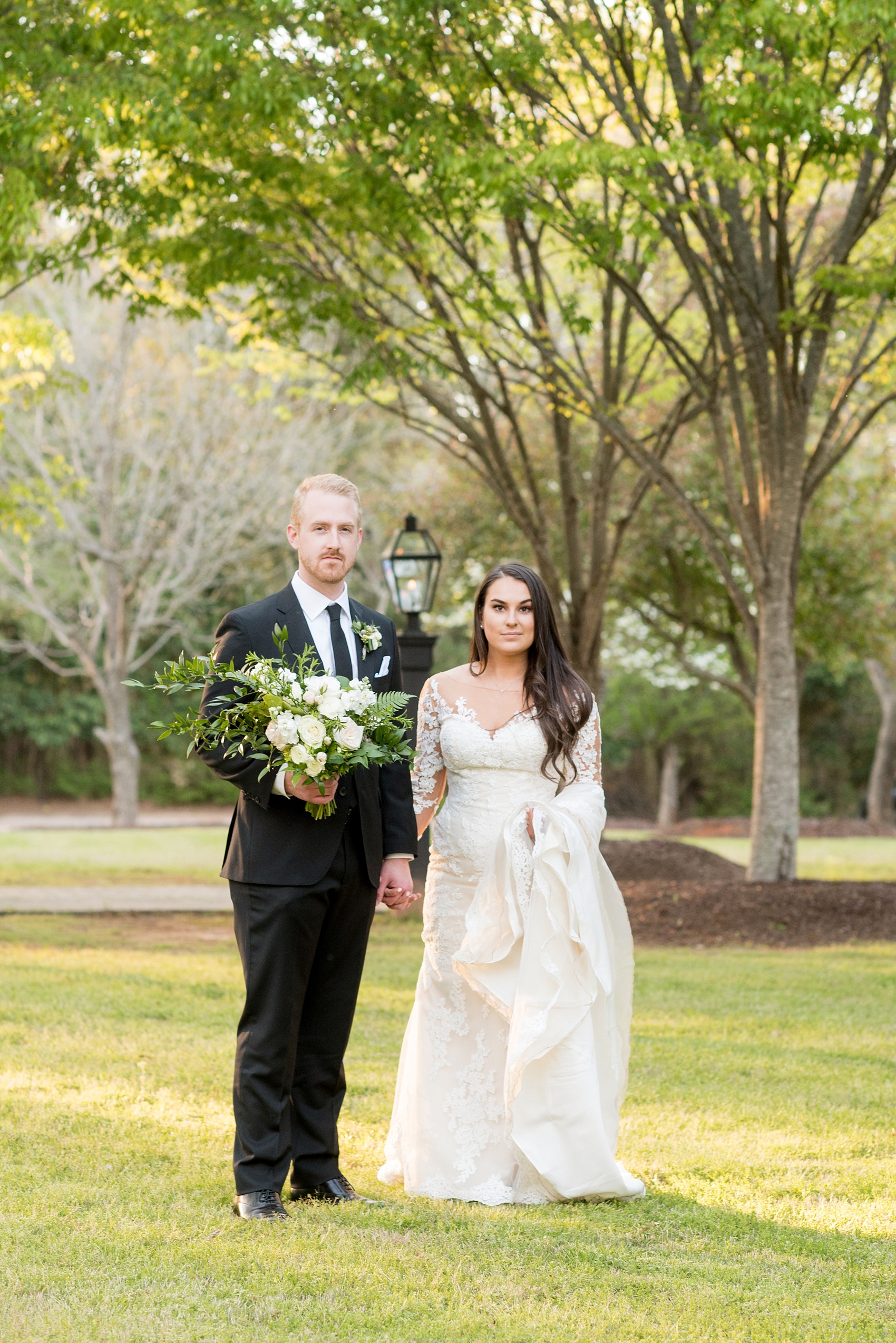 The Sutherland Wedding Photos by Mikkel Paige Photography. Vogue like wedding party picture with the bride in lace Pronovias and groom in a classic black tuxedo. Planning by A Southern Soiree.