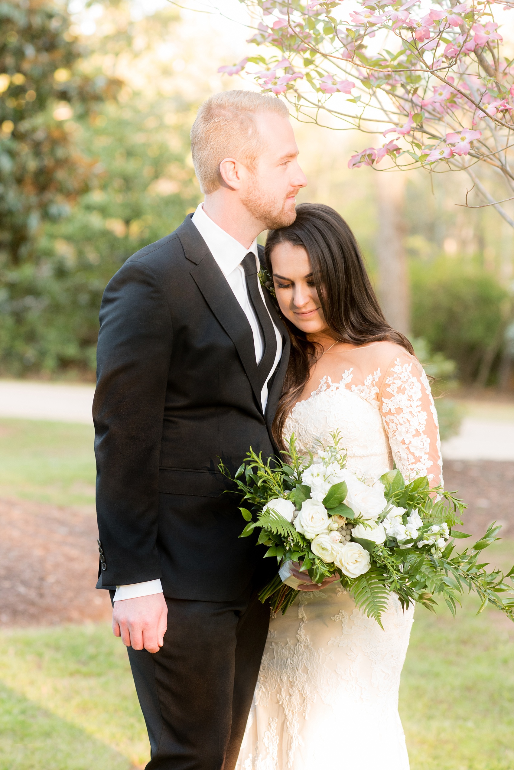 The Sutherland Wedding Photos by Mikkel Paige Photography. Bride and groom picture with a lace Pronovias gown and classic black tuxedo. Planning by A Southern Soiree. Green and white floral bouquet by Eclectic Sage.