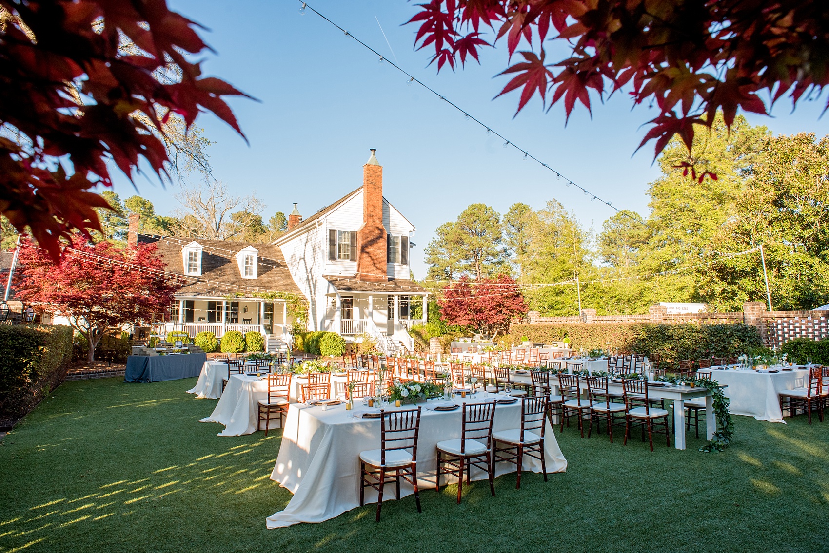 The Sutherland Wedding Photos by Mikkel Paige Photography. Rectangular reception farm tables in the walled garden by Cottage Luxe, with gold geometric candle holders, eucalyptus leaf garland and wooden chargers. Planning by A Southern Soiree.