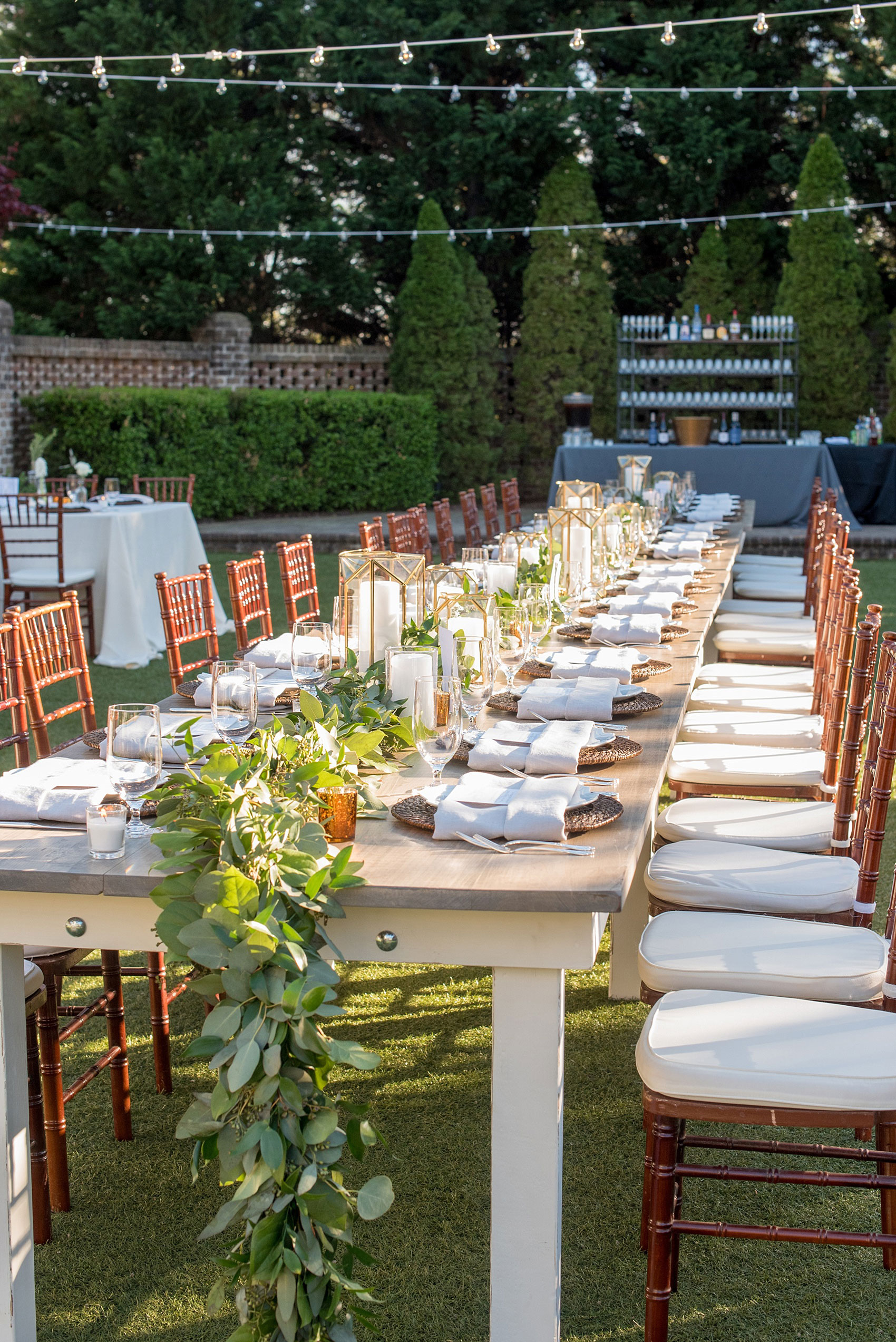 The Sutherland Wedding Photos by Mikkel Paige Photography. Grey and white farm tables by Cottage Luxe, with gold geometric candle holders, eucalyptus leaf garland and wooden chargers. Planning by A Southern Soiree.