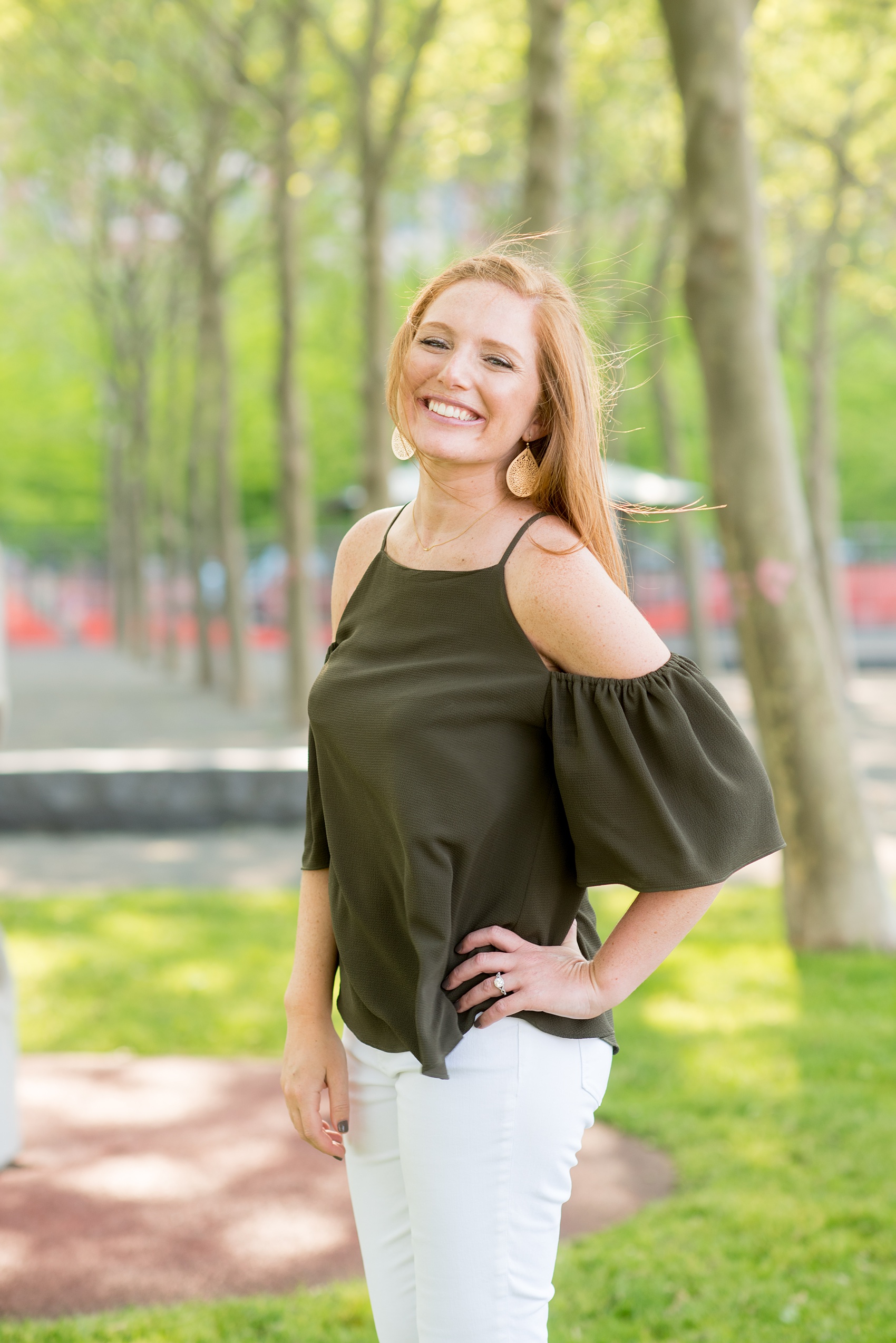 Spring Hoboken Engagement Photos by Mikkel Paige Photography. Picture of the bride in a keyhole cold-shoulder green shirt and white jeans and sandals.