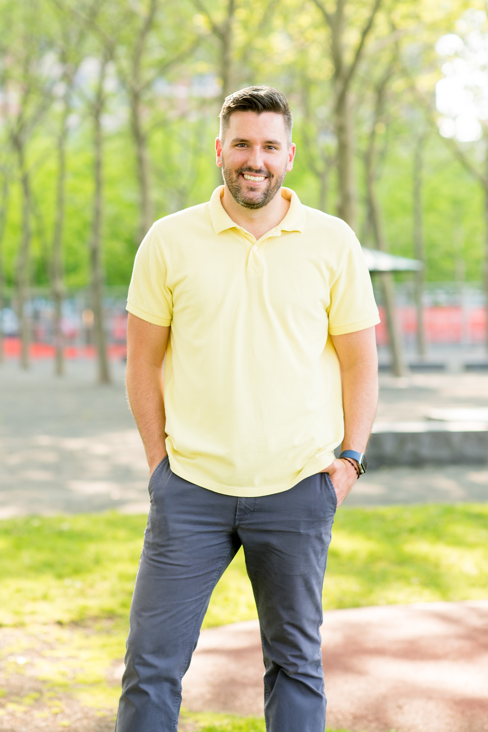 Spring Hoboken Engagement Photos by Mikkel Paige Photography. Picture of the groom in a yellow collared shirt and blue pants.