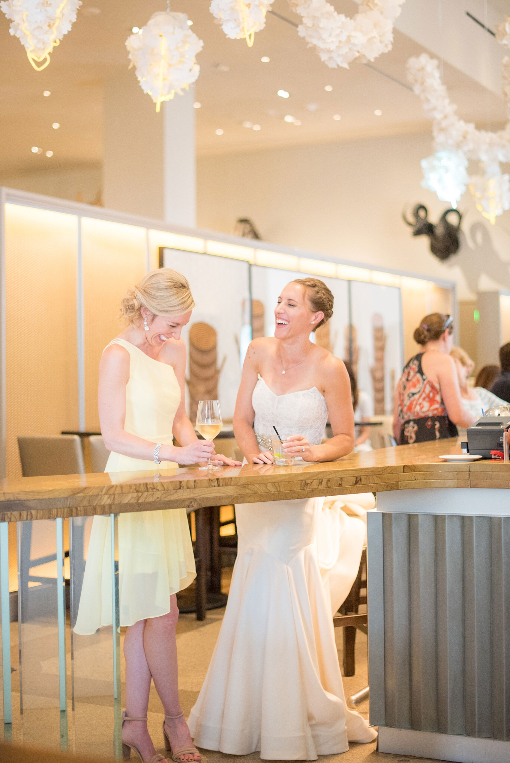 The Cookery Durham wedding photos by Mikkel Paige Photography. Picture of the bride and her Maid of Honor before the ceremony, enjoying cocktails at 21c Museum Hotel bar.
