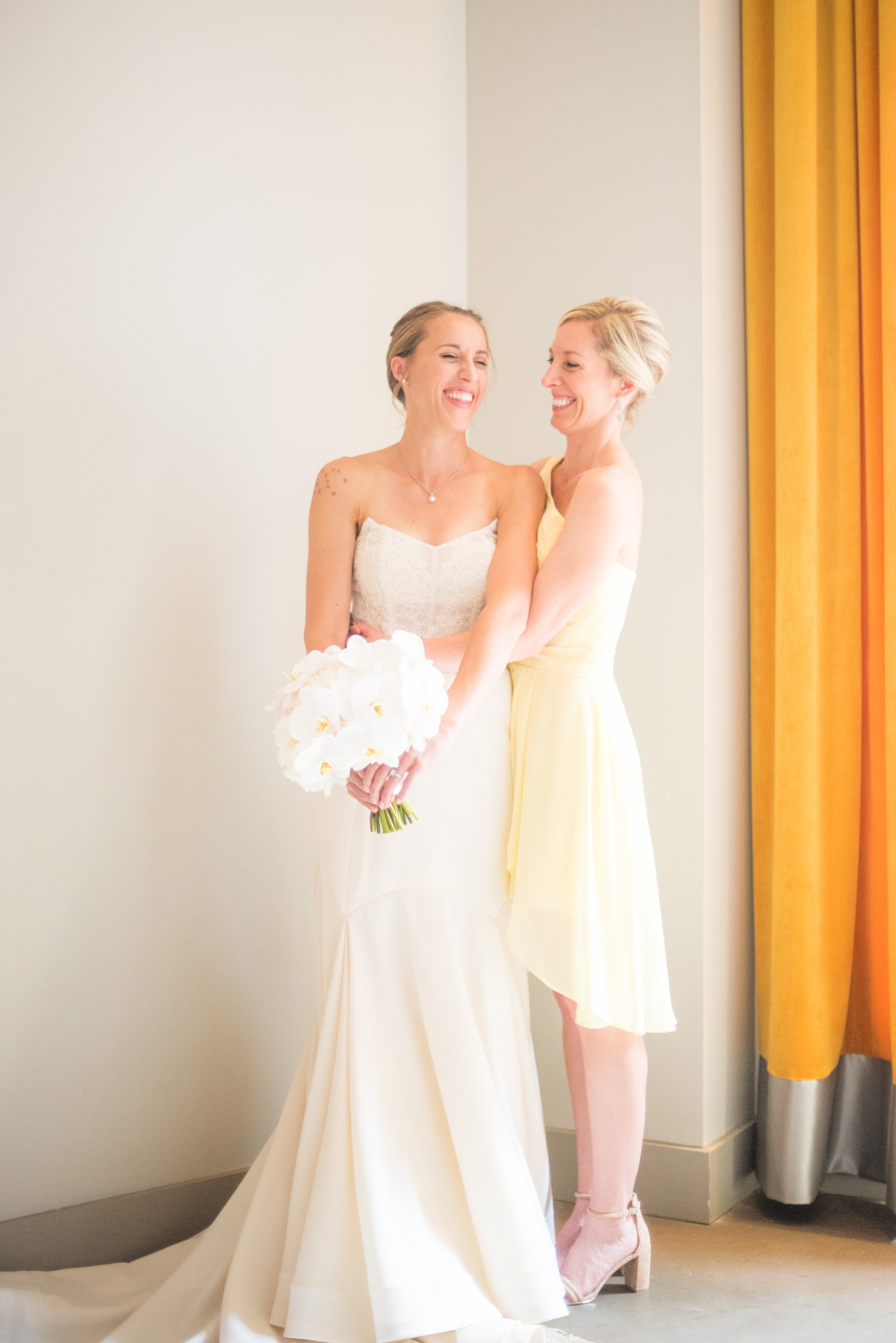 The Cookery Durham wedding photos by Mikkel Paige Photography. Picture of the bride and her bridesmaid in a yellow dress with white orchid bouquets.