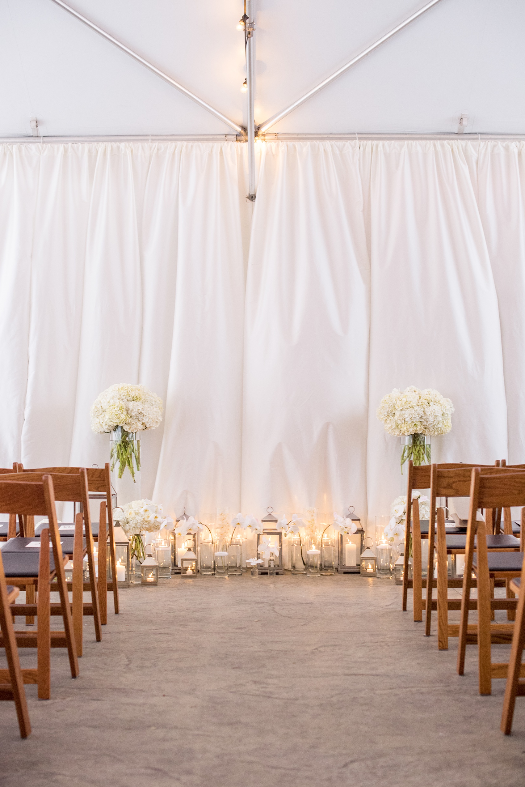 The Cookery Durham wedding photos by Mikkel Paige Photography. Picture of the tented ceremony with candlelight and white flowers including orchids and hydrangeas.