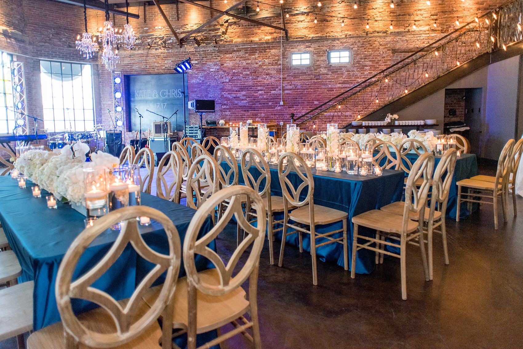 The Cookery Durham wedding photos by Mikkel Paige Photography. Picture of the teal and neutral colored wood palette by Erin McLean Events. Candlelight and rectangular tables were the seating for guests in this charming venue.