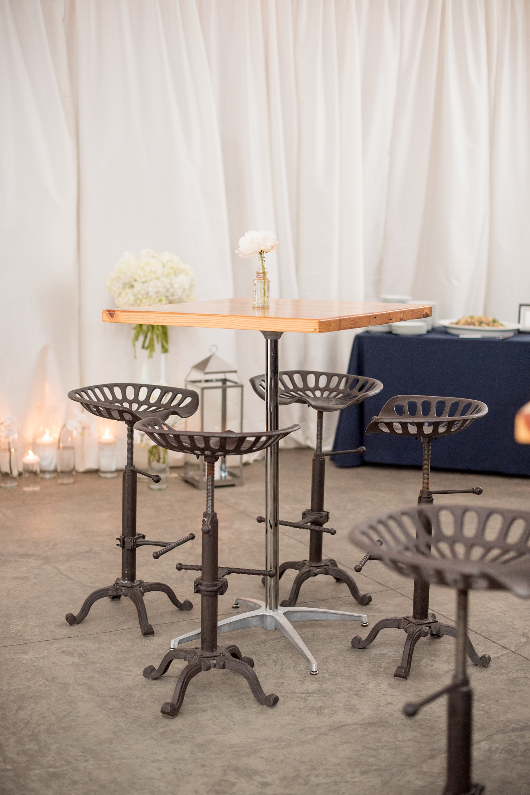 The Cookery Durham wedding photos by Mikkel Paige Photography. Picture of high top seating with a single bud vase and iron bar stools. Planning by Erin McLean Events.