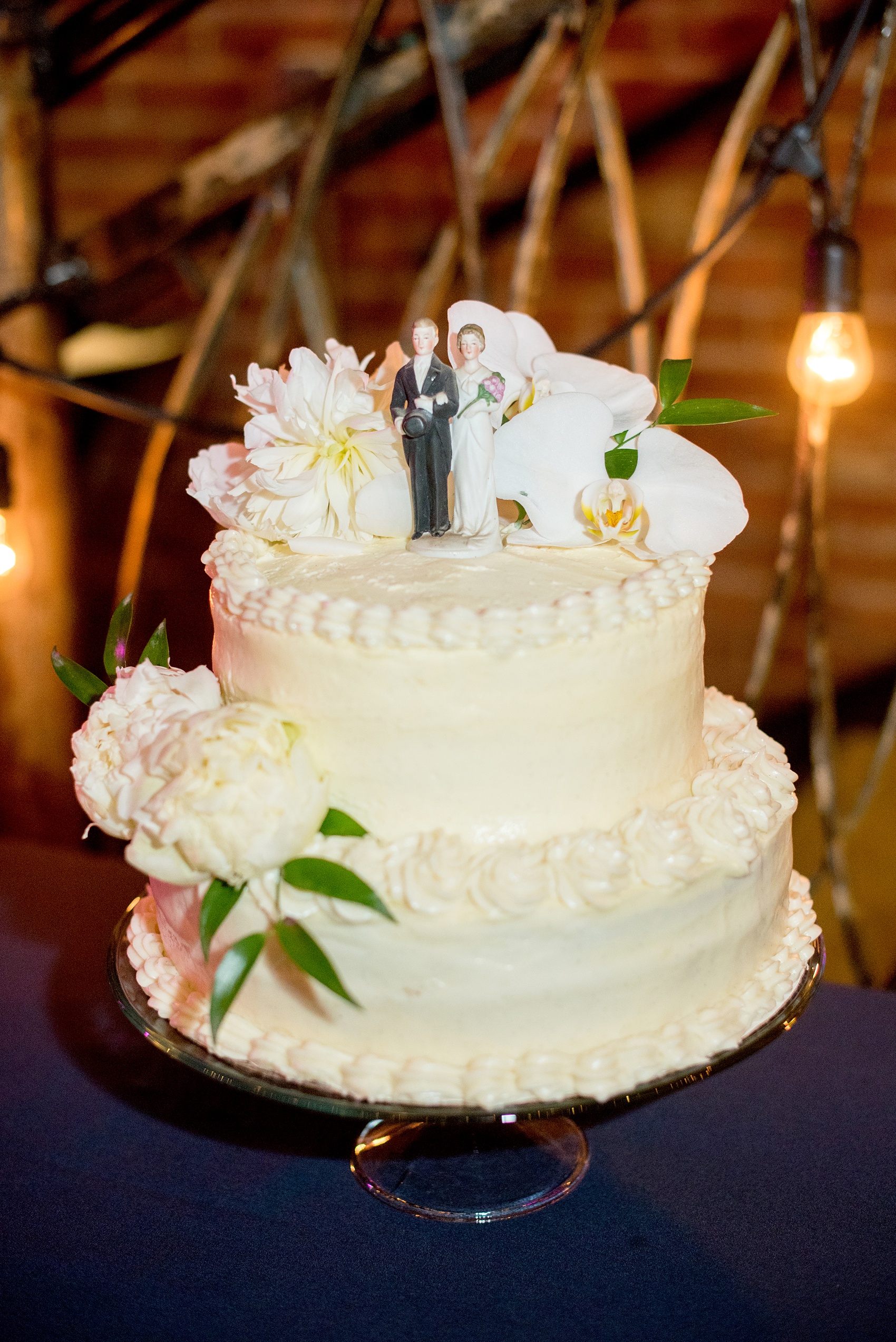 The Cookery Durham wedding photos by Mikkel Paige Photography. Picture of the bride and groom's small vanilla bean buttercream cake with heirloom bride and groom topper.