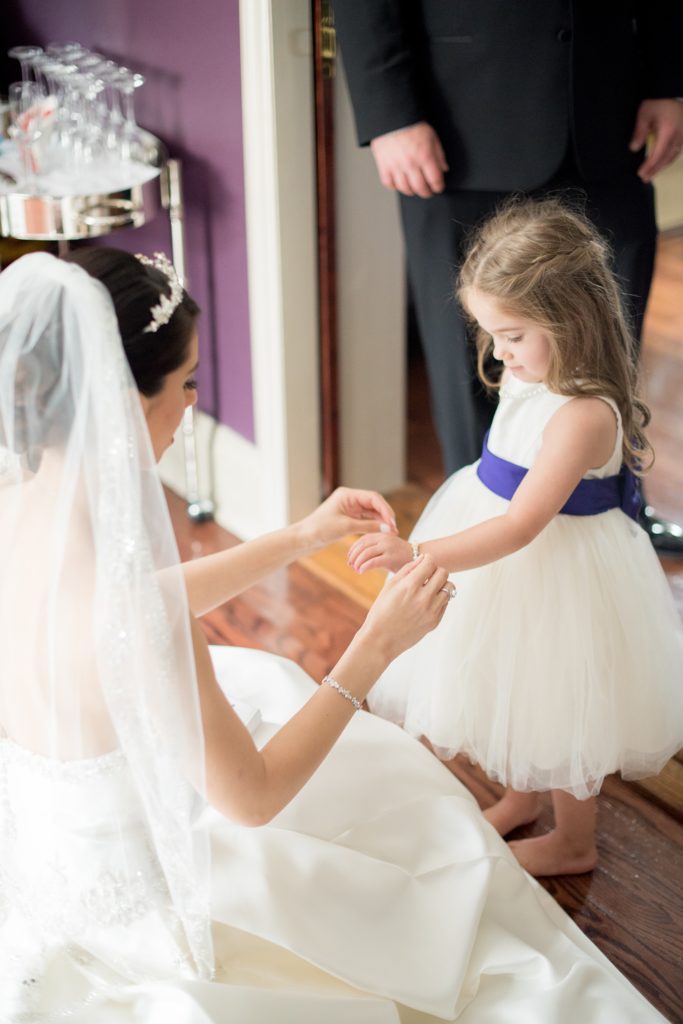 Mikkel Paige Photography wedding photos at The Fox Hollow, Long Island. A candid photo of the bride giving her flower girl a gift.