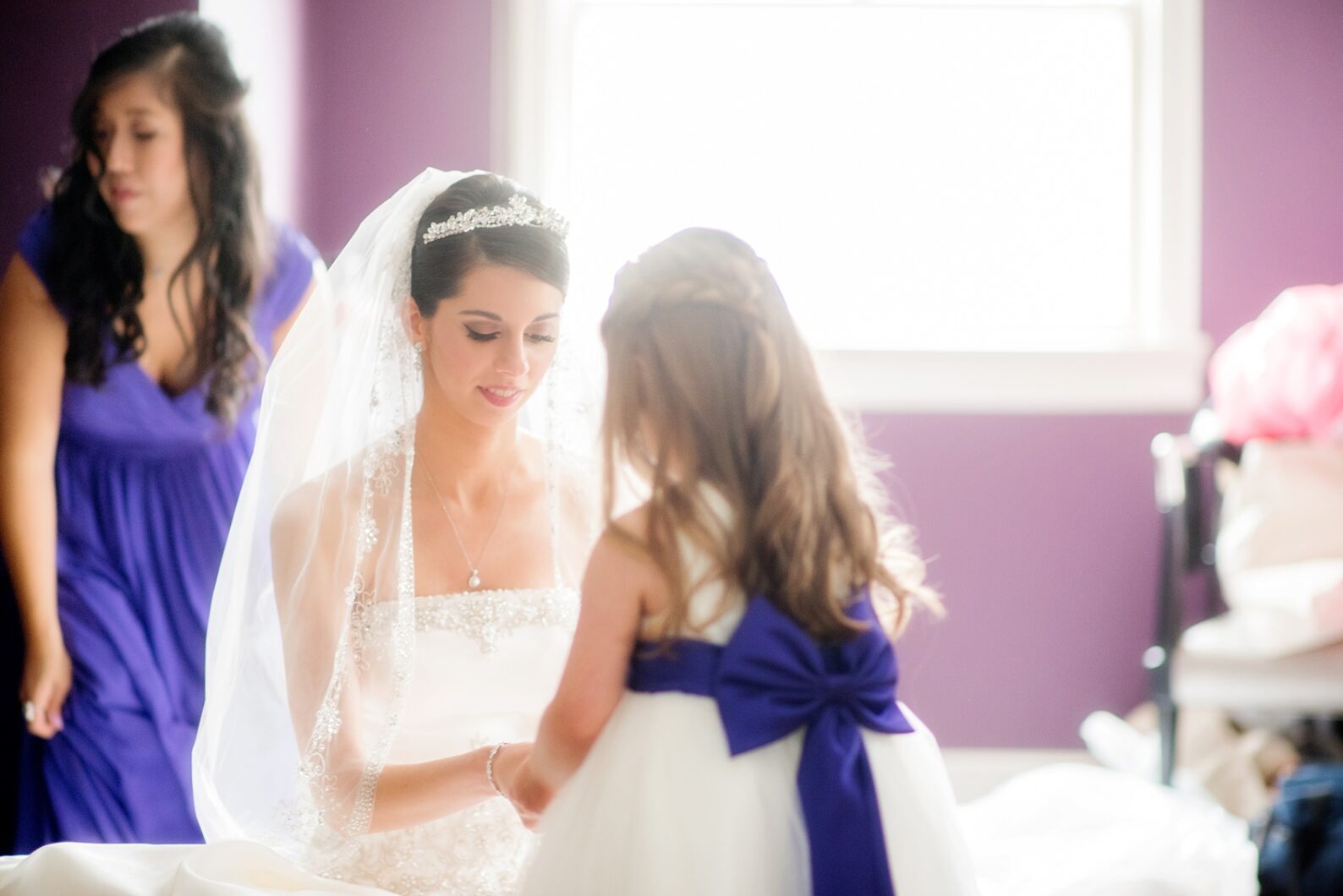 Mikkel Paige Photography wedding photos at The Fox Hollow, Long Island. A candid photo of the bride giving her flower girl a gift.