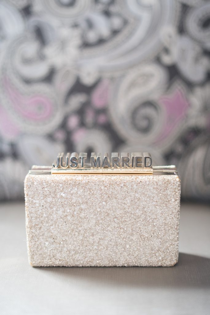 Mikkel Paige Photography wedding photos at The Fox Hollow, Long Island. Detail picture of the bride's "Just Married" Kate Spade glitter clutch.