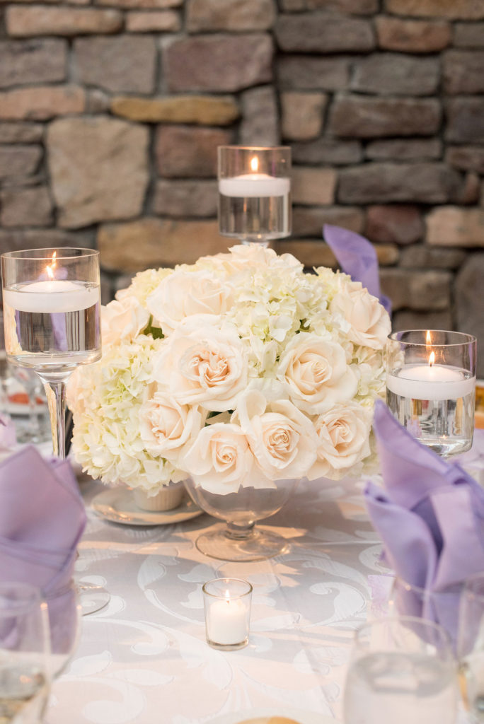 Mikkel Paige Photography wedding photos at The Fox Hollow. Picture of a reception table with a white orchids, roses and hydrangeas centerpiece and floating candles.