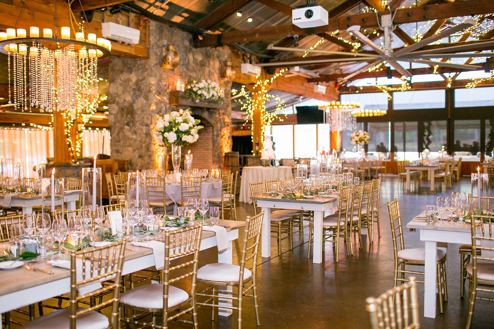 Pavilion at Angus Barn wedding photos by Mikkel Paige Photography. Picture of the farm tables from Cottage Luxe drenched in candlelight and eucalyptus garland from Meristem Floral.