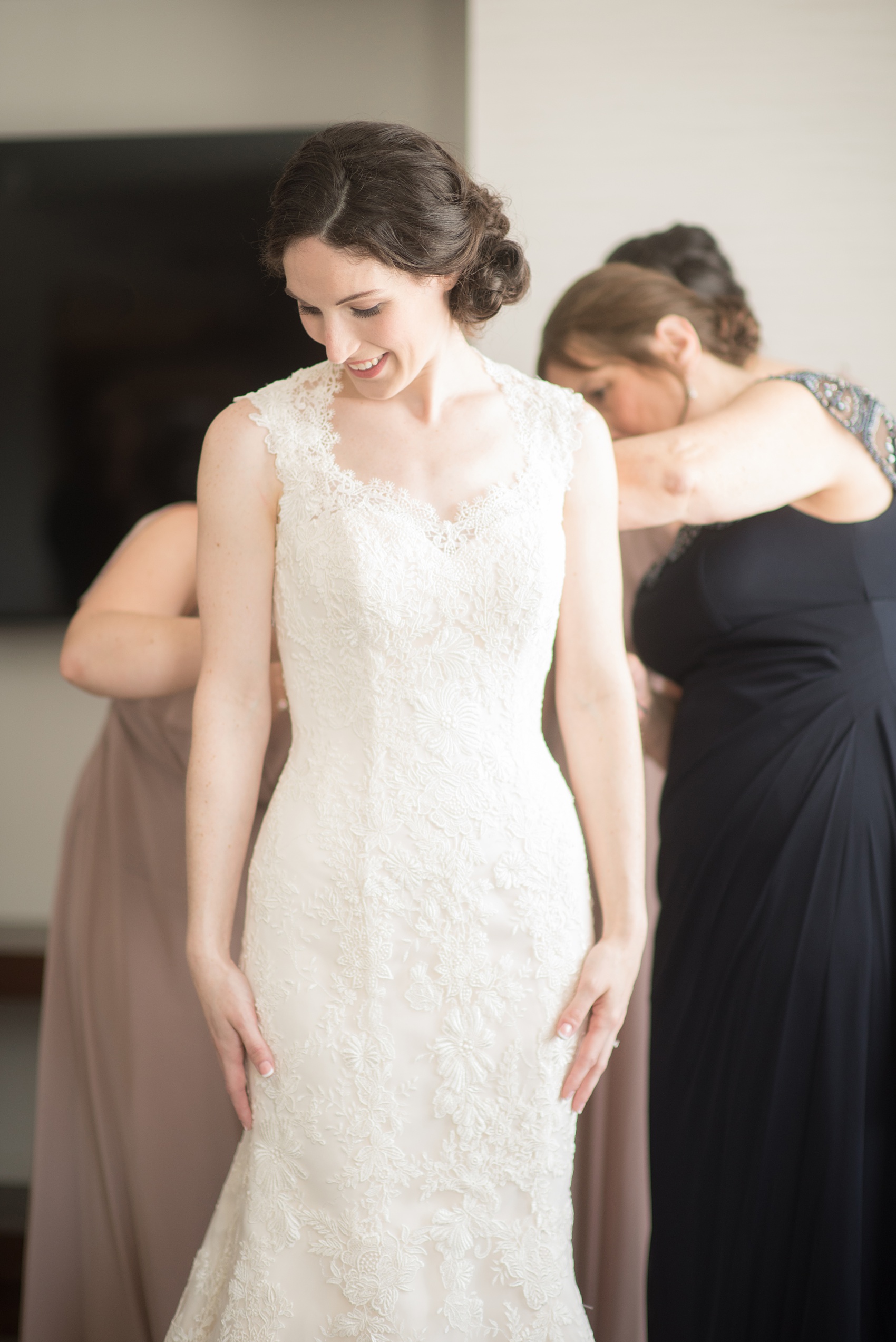 Pavilion at Angus Barn wedding photos by Mikkel Paige Photography. Picture of the bride getting ready in her lace wedding gown by Justin Alexander from Maggi Bridal.