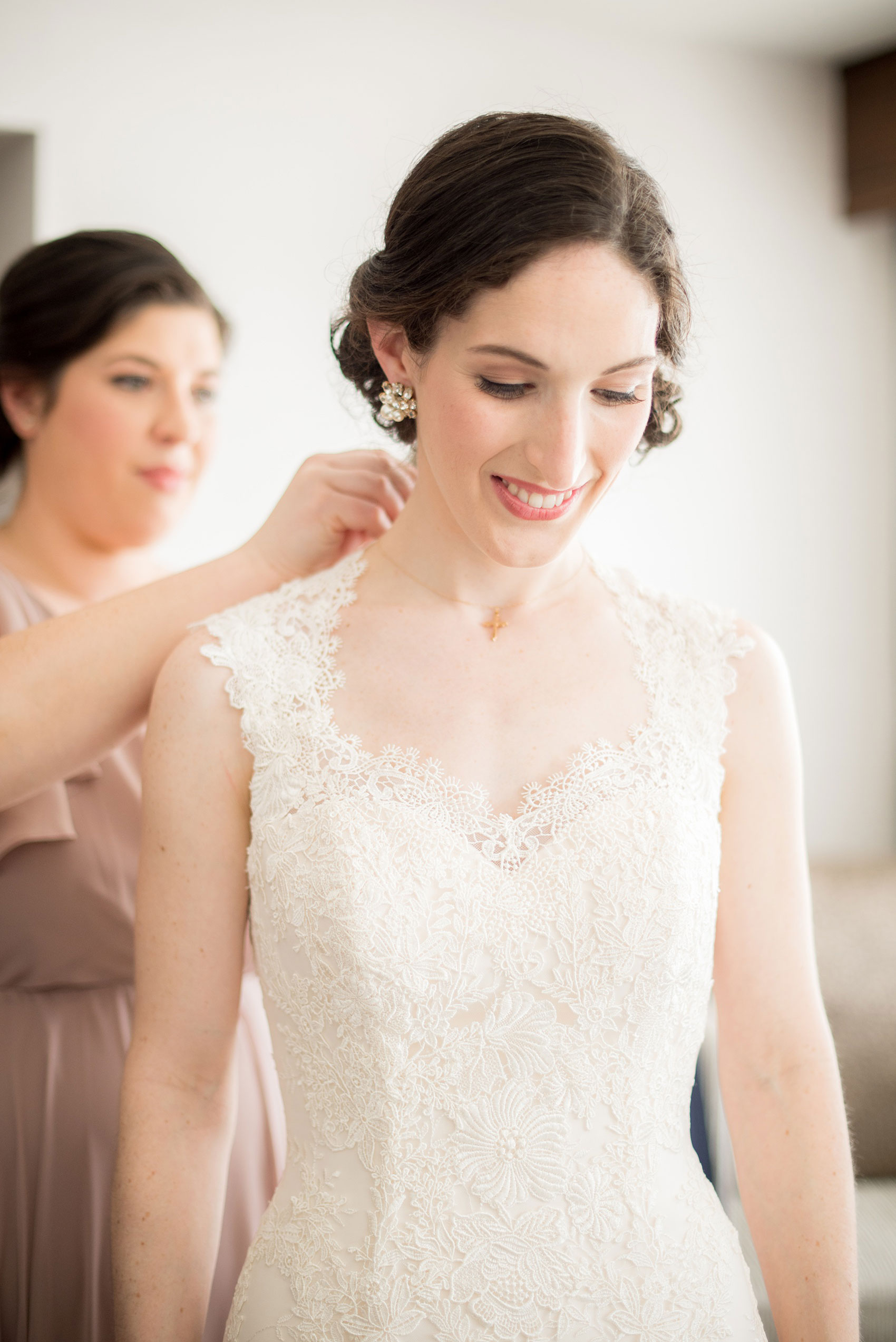 Pavilion at Angus Barn wedding photos by Mikkel Paige Photography. Picture of the bride's Maid of Honor helping her with finishing jewelry details for the day. 