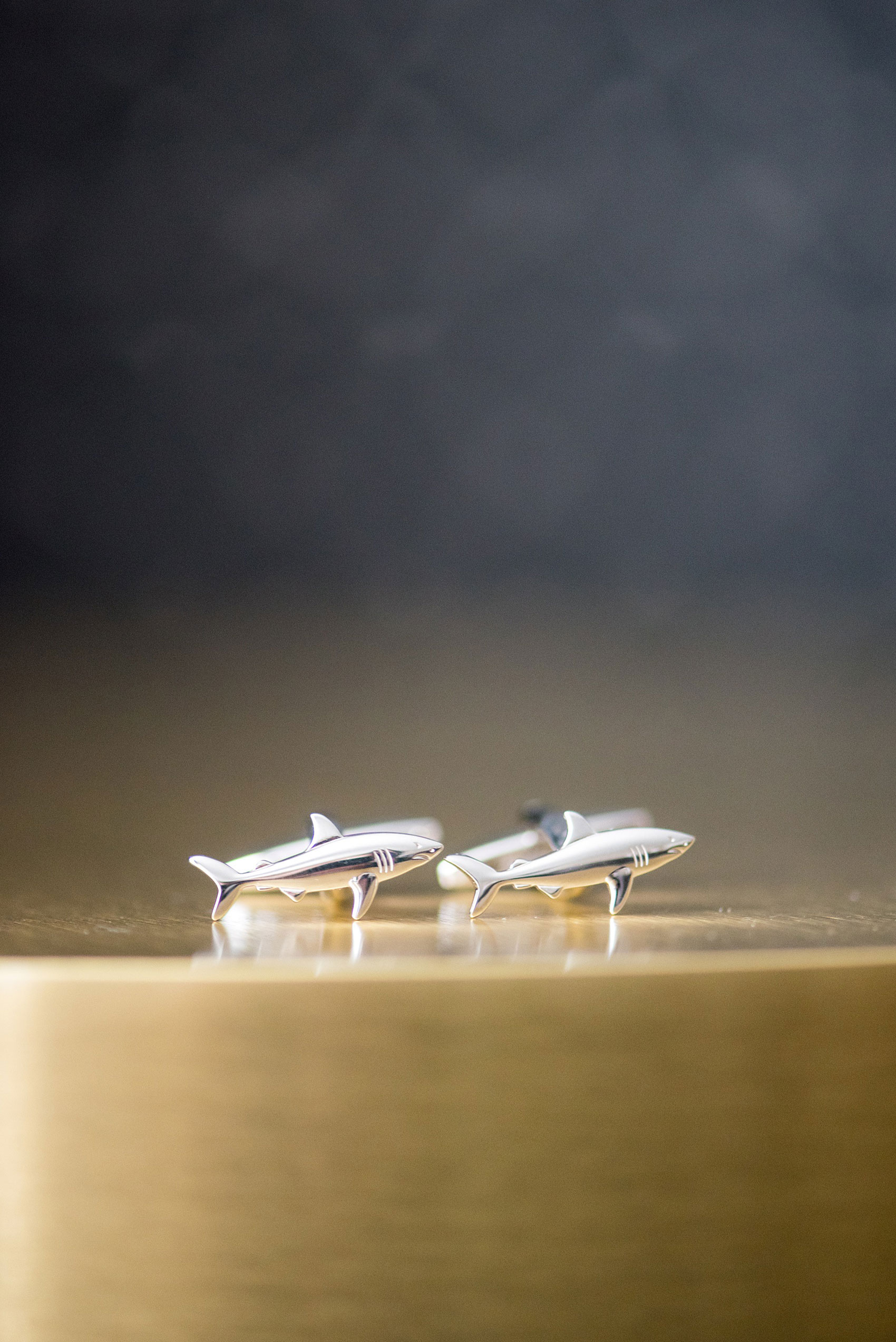 Pavilion at Angus Barn wedding photos by Mikkel Paige Photography. Detail picture of the groom's shark cufflinks.