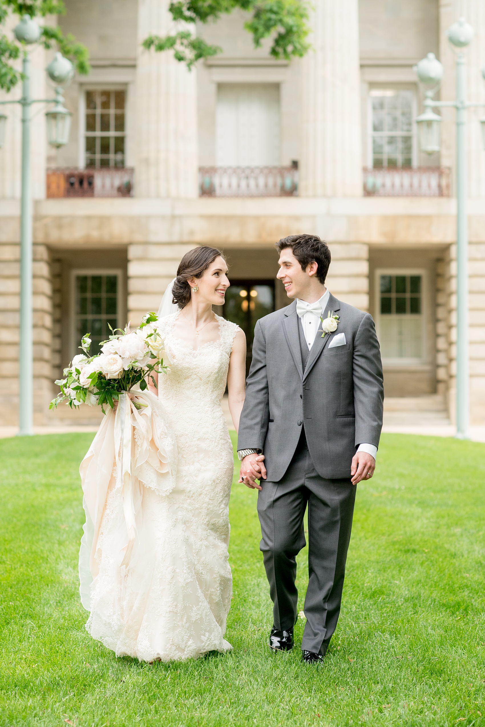 Wedding photos by Mikkel Paige Photography. Picture of the bride and groom at the Raleigh capitol building during a spring day. Flowers by Meristem Floral.