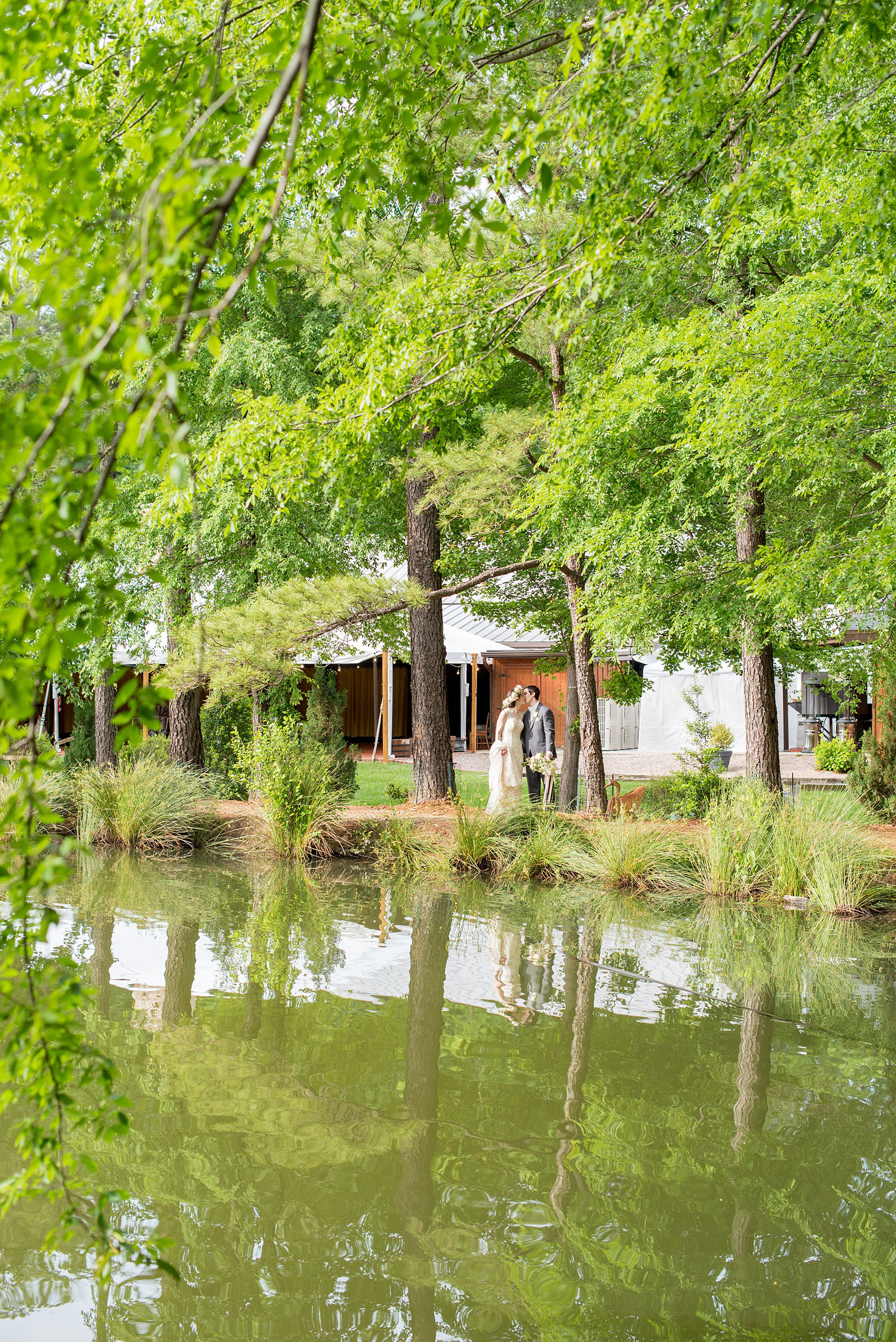 Pavilion at Angus Barn wedding photos by Mikkel Paige Photography. Raleigh spring celebration with flower crown and bouquet by Meristem Floral. Picture of the bride and groom near the venue lake.