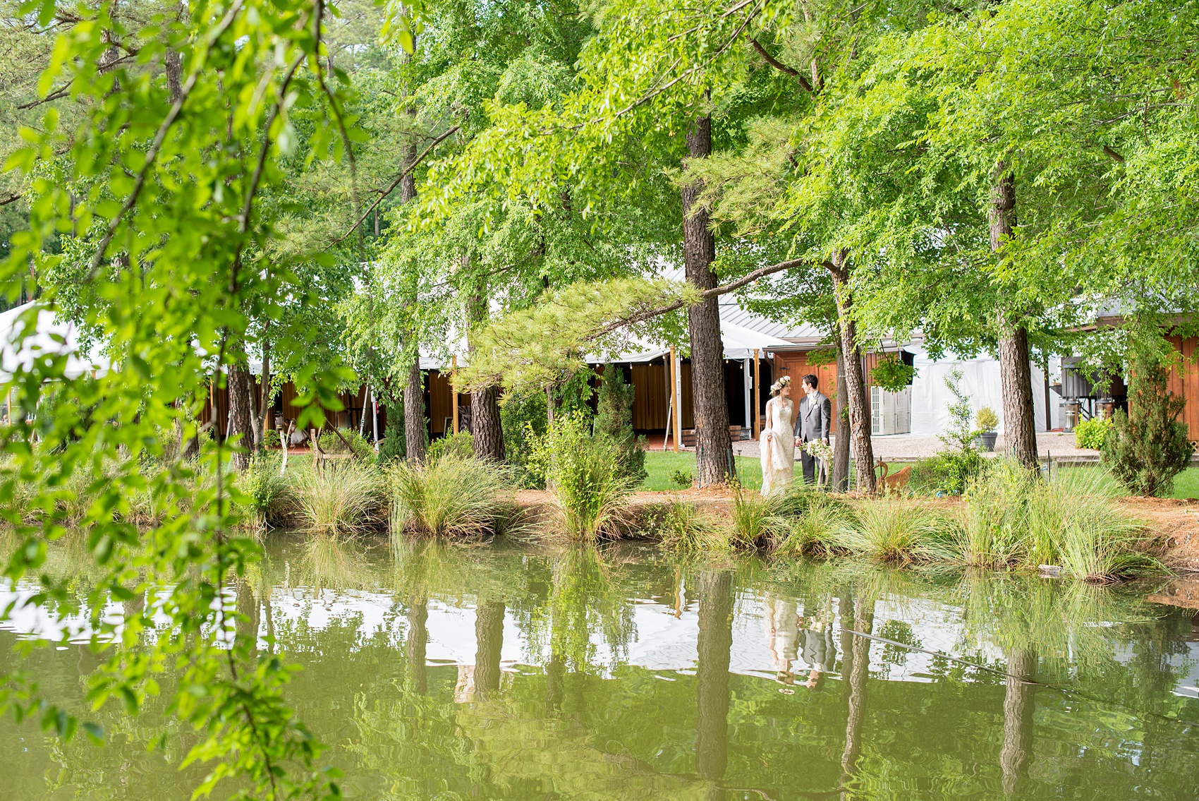 Pavilion at Angus Barn wedding photos by Mikkel Paige Photography. Raleigh spring celebration with flower crown and bouquet by Meristem Floral. Picture of the bride and groom near the venue lake.