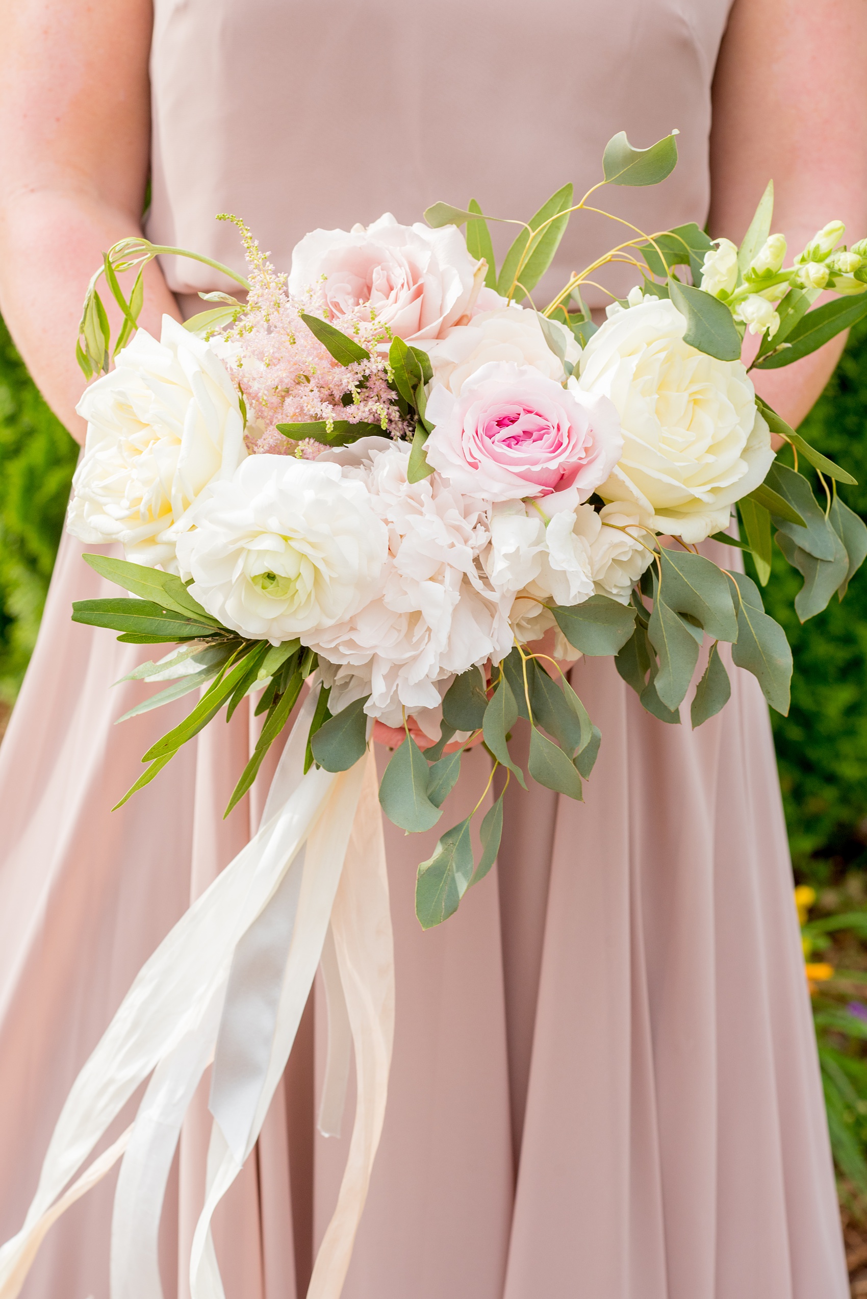 Pavilion at Angus Barn wedding photos by Mikkel Paige Photography. Picture of a bridesmaid in a dusty rose gown holding a whimsical bouquet with peonies, ranunculus, garden roses and eucalyptus by Meristem Floral. Tied with long silk pink and white ribbons. 