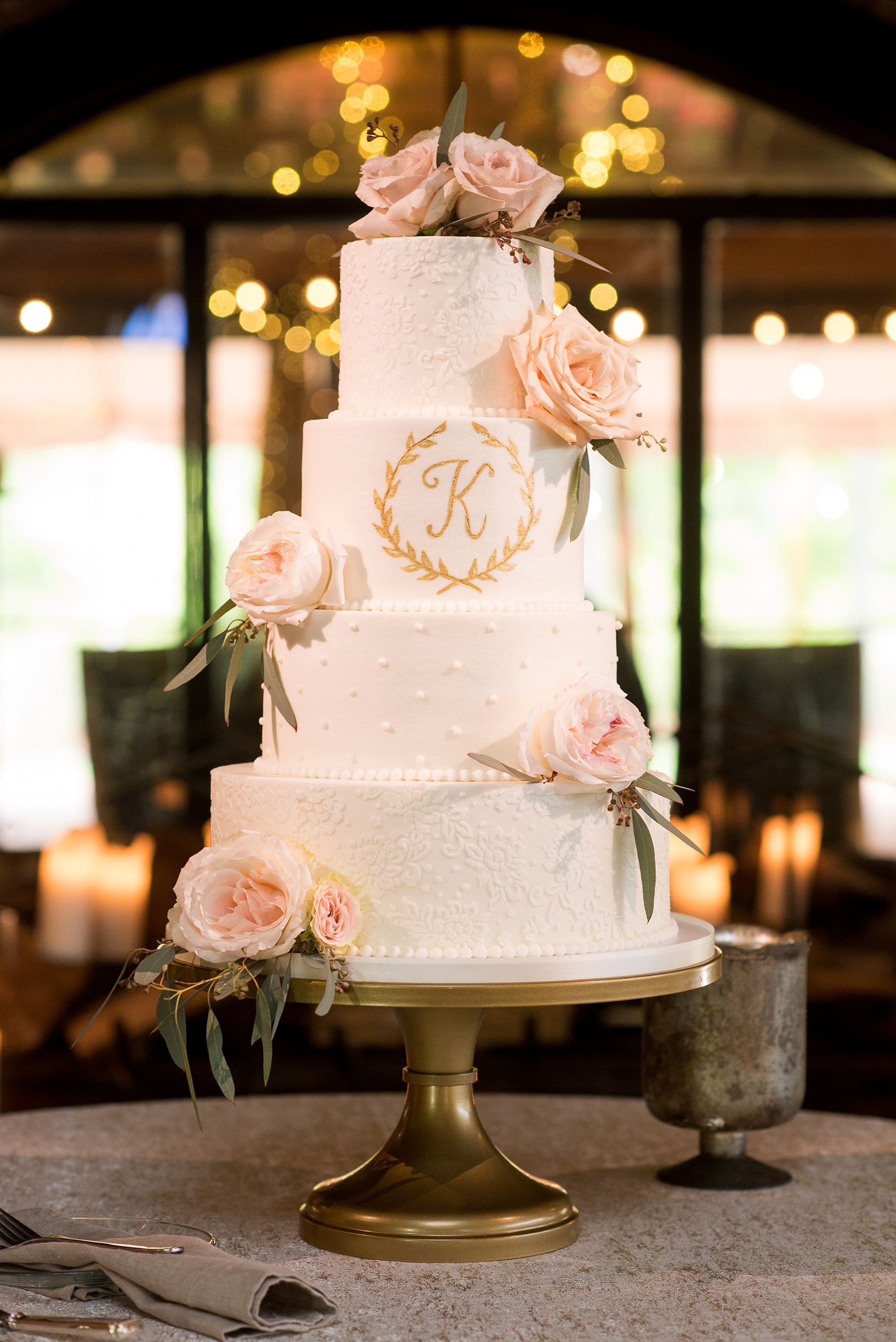 Pavilion at Angus Barn wedding photos by Mikkel Paige Photography. Picture of the white tiered cake by Ashley Cakes with "K" gold monogram detail and garden rose flowers.