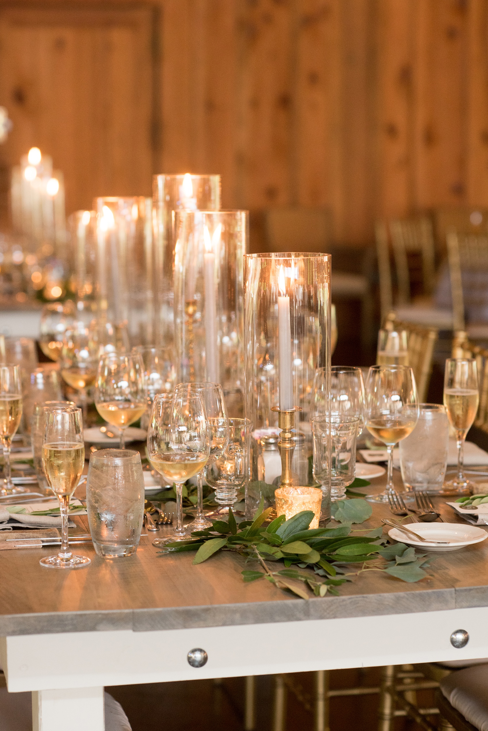 Pavilion at Angus Barn wedding photos by Mikkel Paige Photography. Picture of the farm tables from Cottage Luxe drenched in candlelight and eucalyptus garland from Meristem Floral.