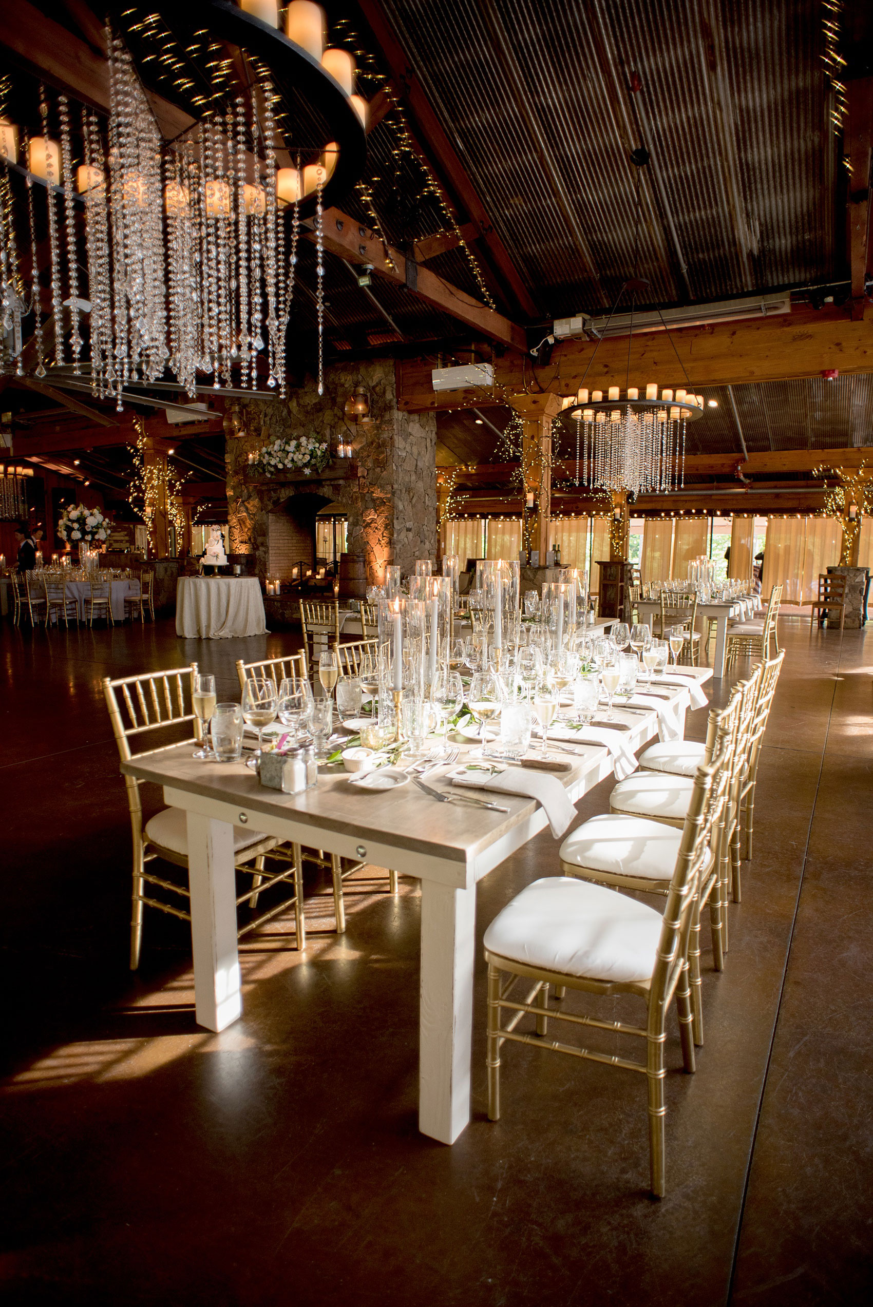 Pavilion at Angus Barn wedding photos by Mikkel Paige Photography. Picture of the farm tables from Cottage Luxe drenched in candlelight and eucalyptus garland from Meristem Floral.