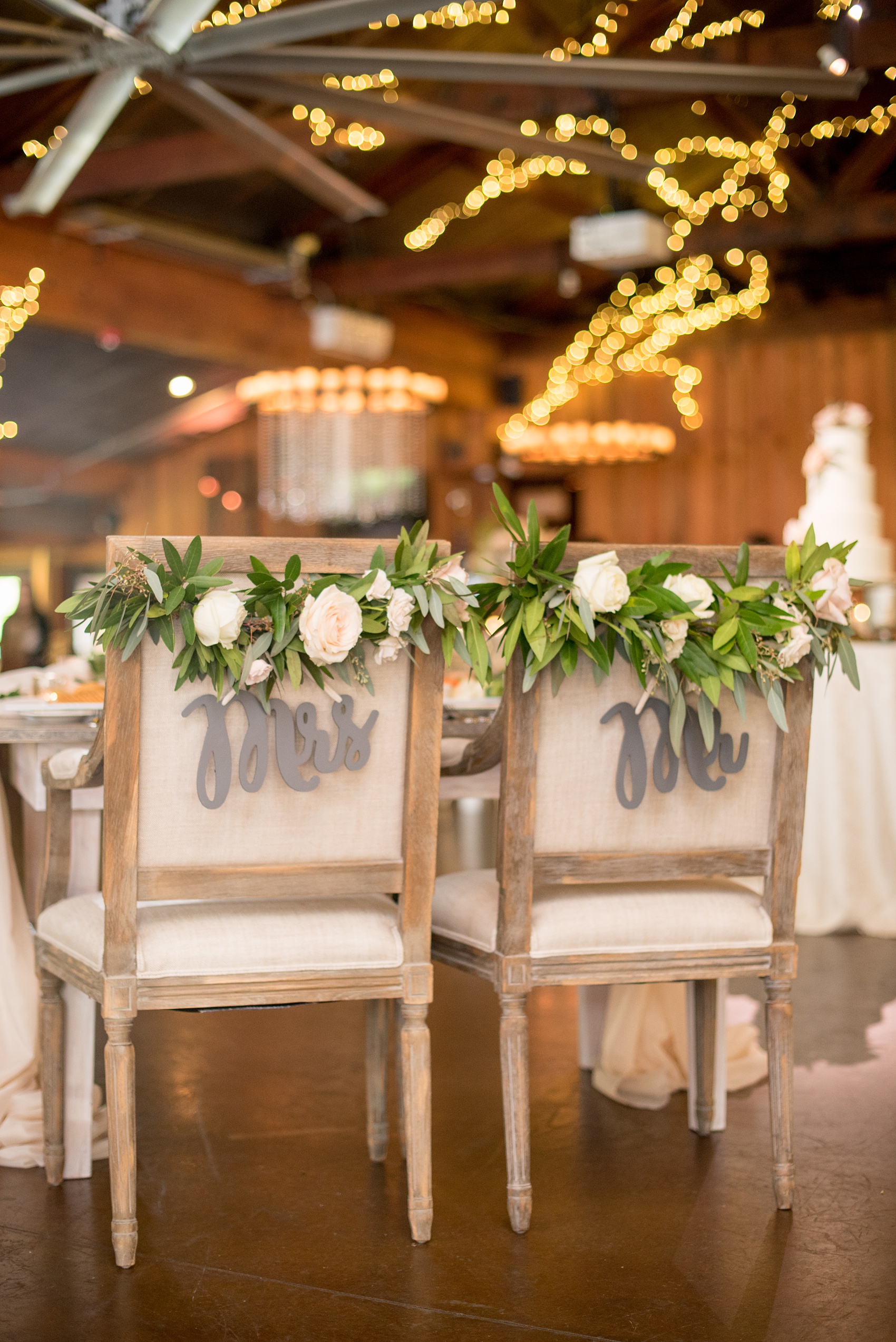 Pavilion at Angus Barn wedding photos by Mikkel Paige Photography. Picture of the sweetheart farm table chairs from Cottage Luxe, topped with flowers by Meristem Floral.