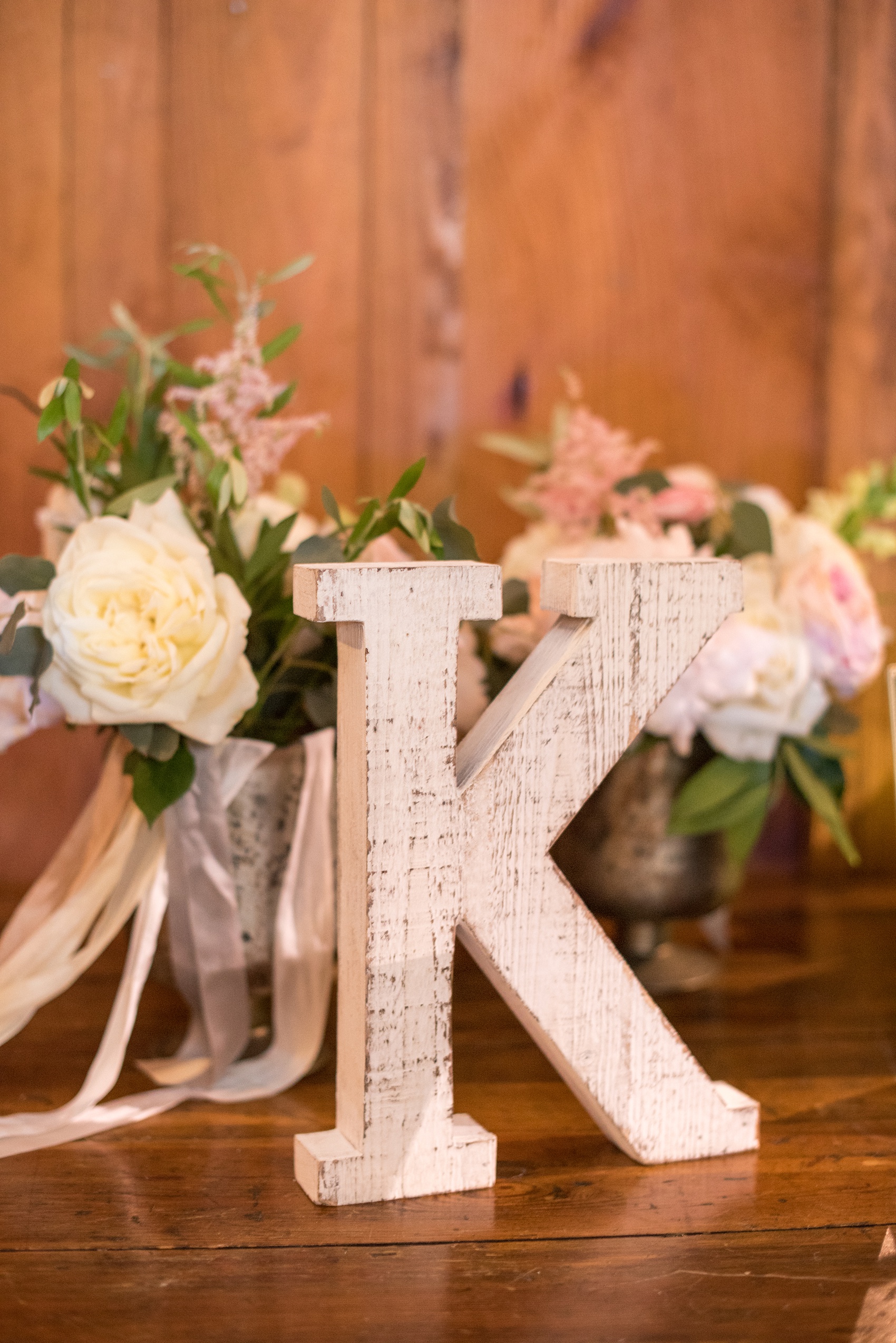 Pavilion at Angus Barn wedding photos by Mikkel Paige Photography. Picture of a rustic white, shabby chic inspired K monogram wood block on the framed photo table.