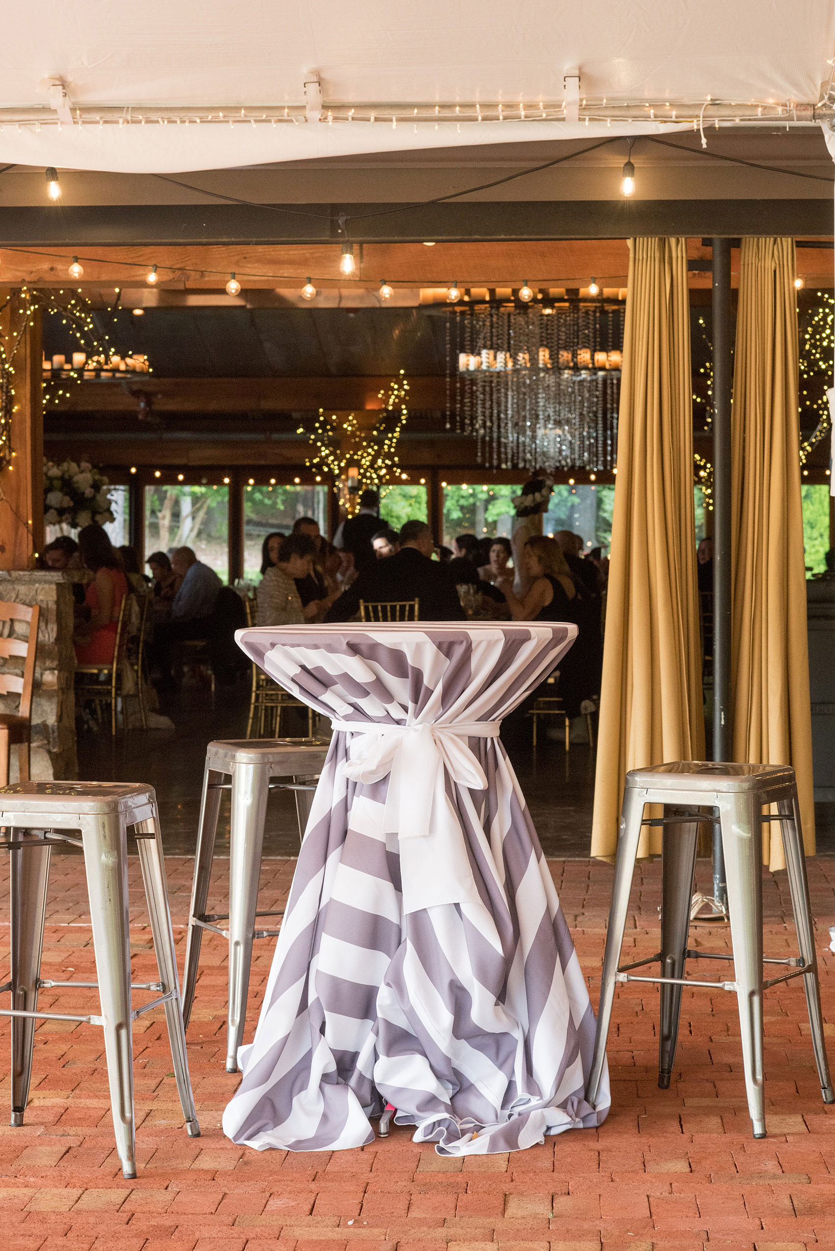 Pavilion at Angus Barn wedding photos by Mikkel Paige Photography. Picture of the high top cocktail table in a white and grey striped linen.