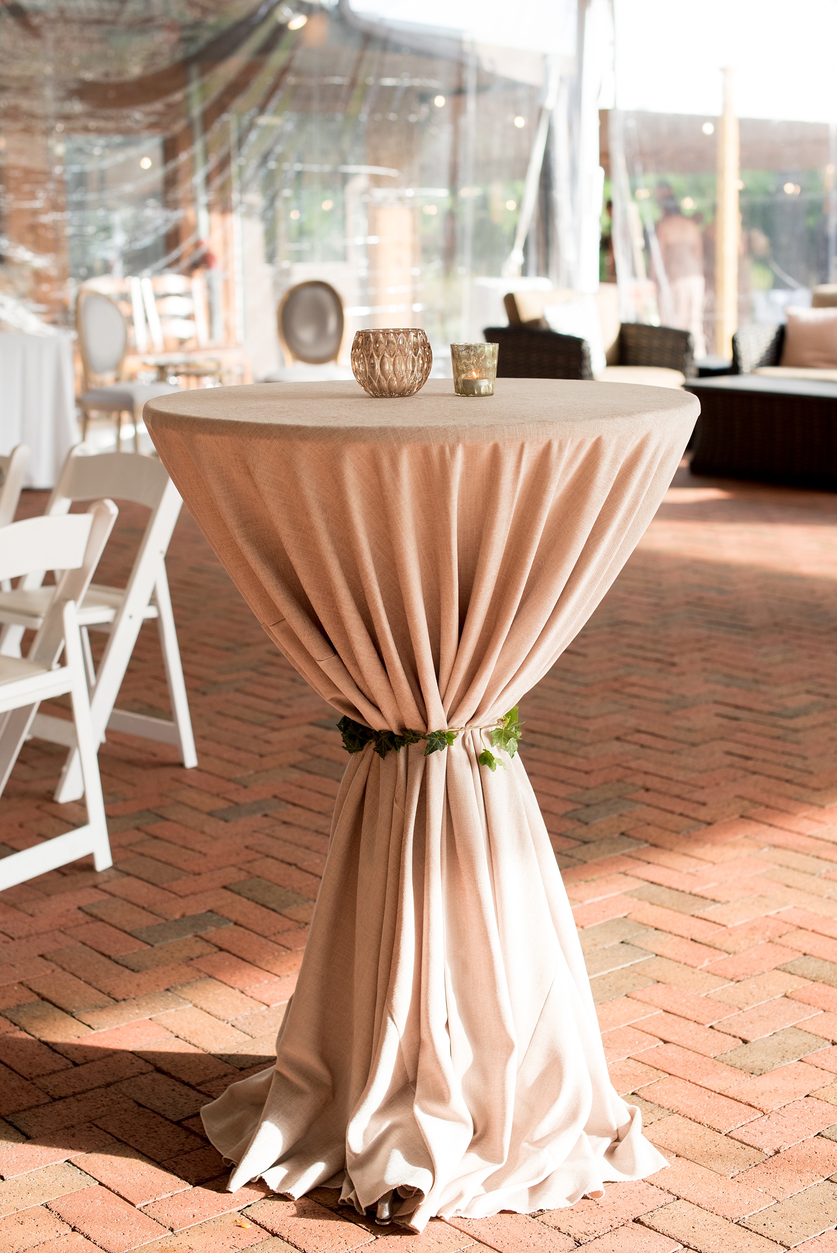 Pavilion at Angus Barn wedding photos by Mikkel Paige Photography. Picture of a high top cocktail table in a sand colored linen held with a string of ivy.