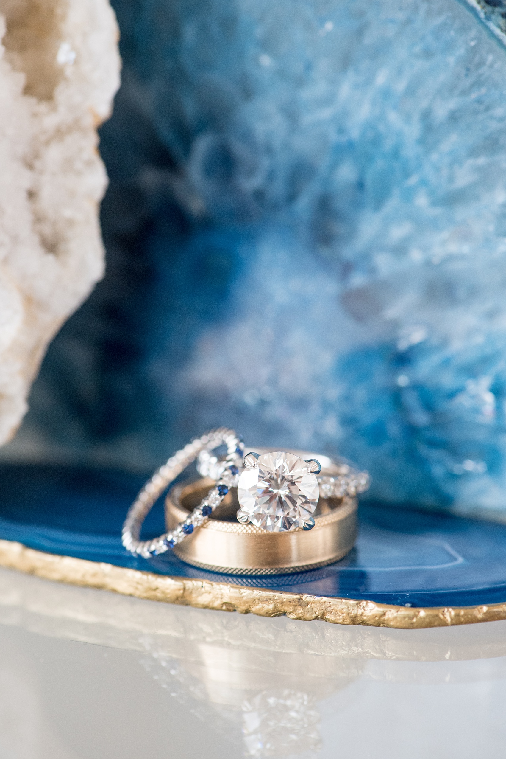 The Glass Box Raleigh wedding photos by Mikkel Paige Photography. Detail picture of the diamond and sapphire rings on blue agate.