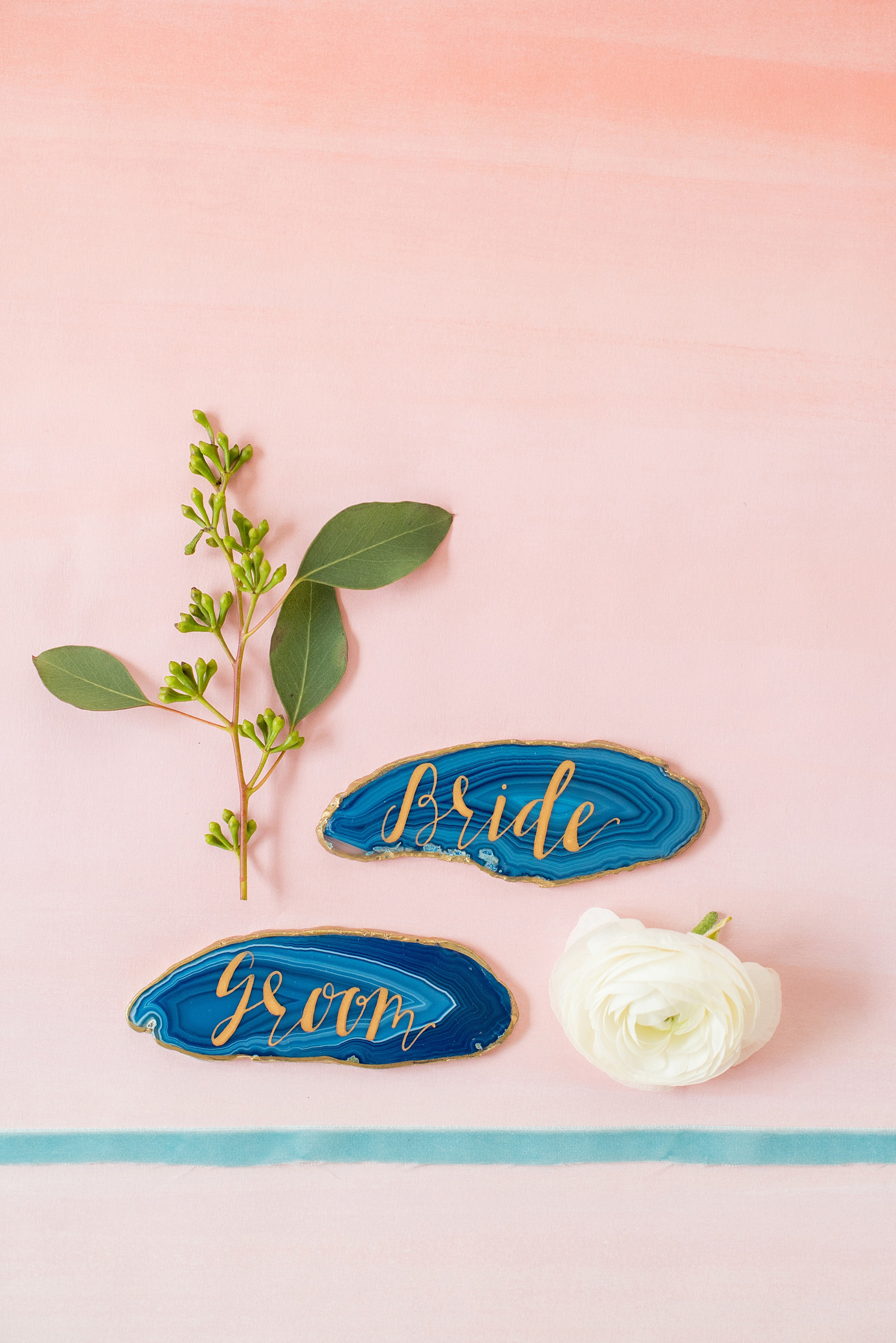 The Glass Box Raleigh wedding photos by Mikkel Paige Photography. Detail picture of the blue agate gem bride and groom escort pieces with gold calligraphy.