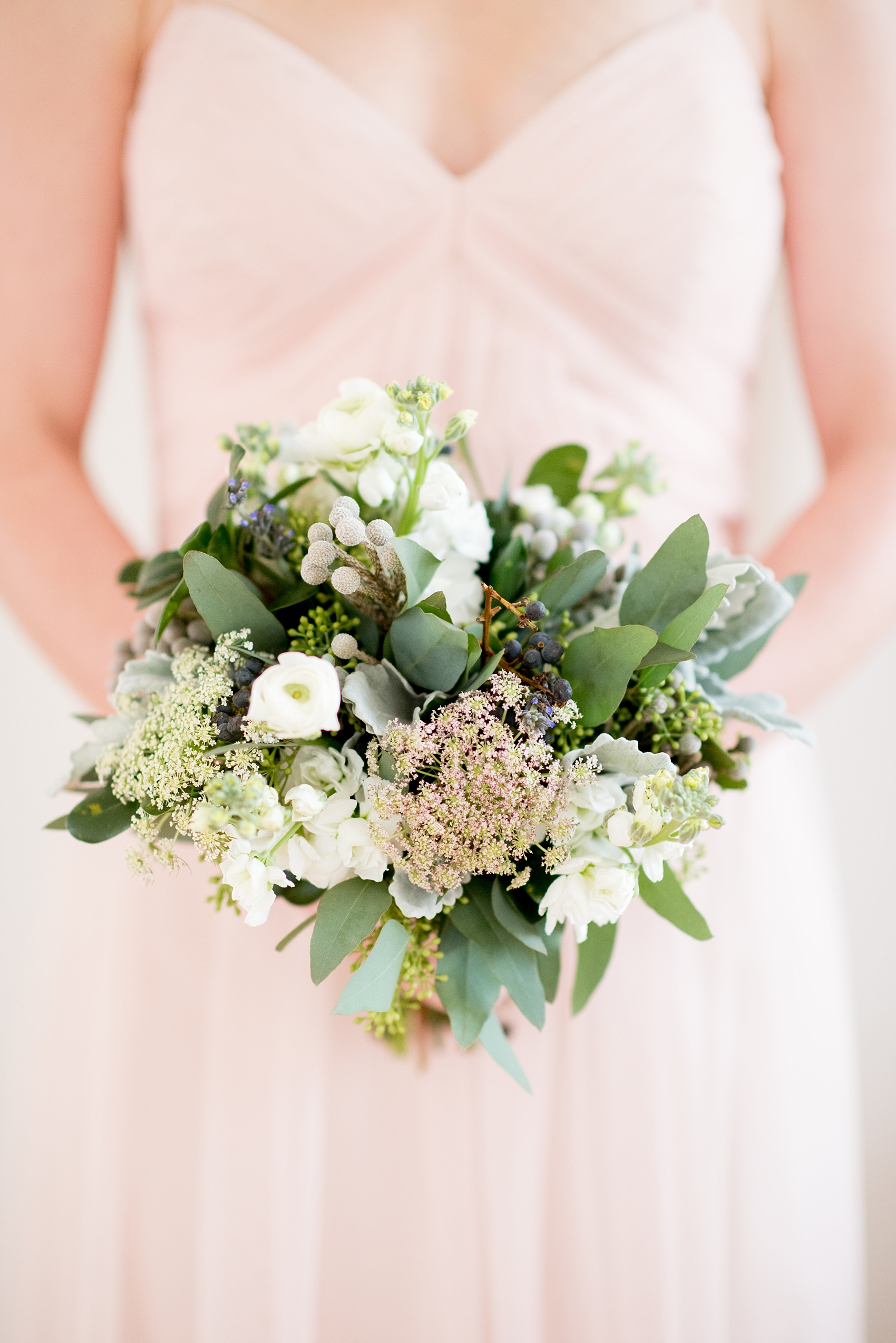 The Glass Box Raleigh wedding photos by Mikkel Paige Photography. Picture of the bridesmaid bouquet of white ranunculus, berries and green eucalyptus.