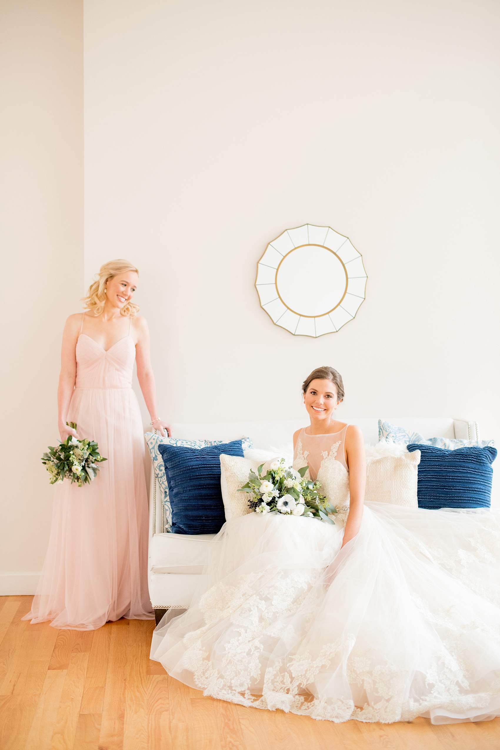 The Glass Box Raleigh wedding photos by Mikkel Paige Photography. Picture of the bride in a Lazaro gown in this modern downtown venue. The bridesmaid wore a pink Hayley Paige occasion gown.