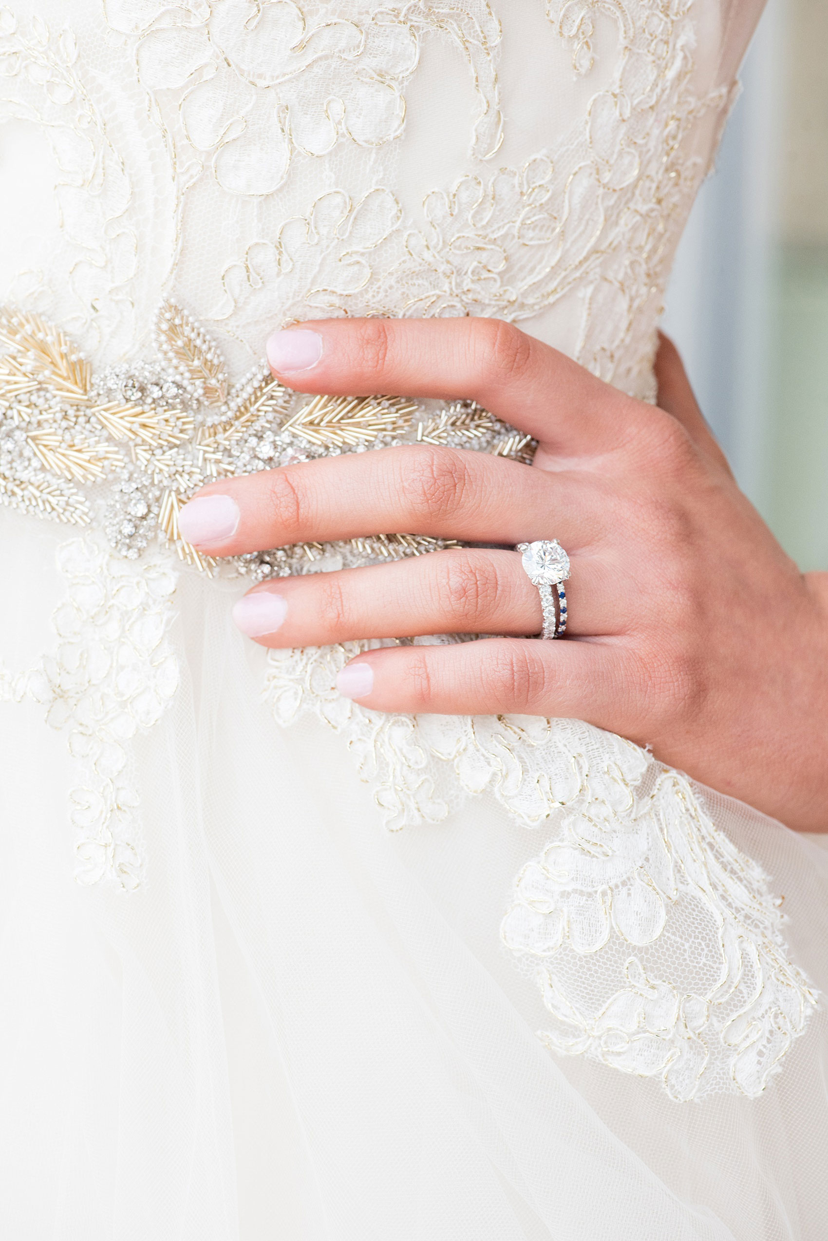 The Glass Box Raleigh wedding photos by Mikkel Paige Photography. Picture of the bride's Lazaro gown beading detail and diamond engagement ring and sapphire band.