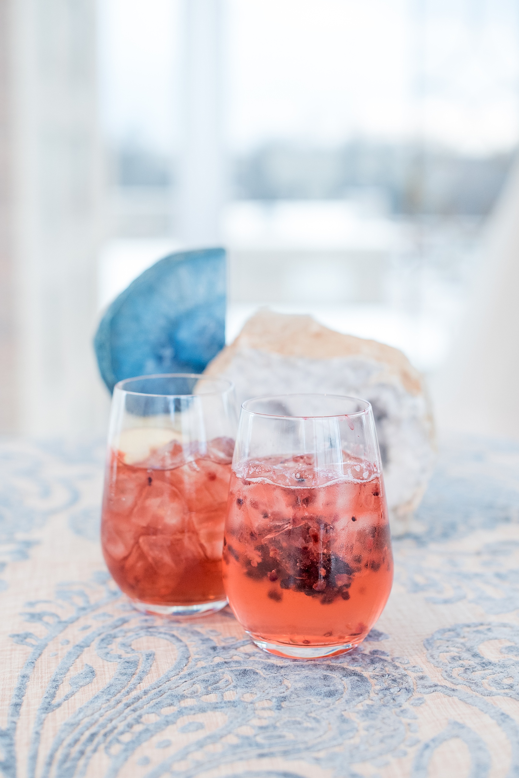 The Glass Box Raleigh wedding photos by Mikkel Paige Photography. Picture of berry cocktails and agate on a blue and white linen. Beverages by On the Rocks bartending in this modern downtown venue in North Carolina.