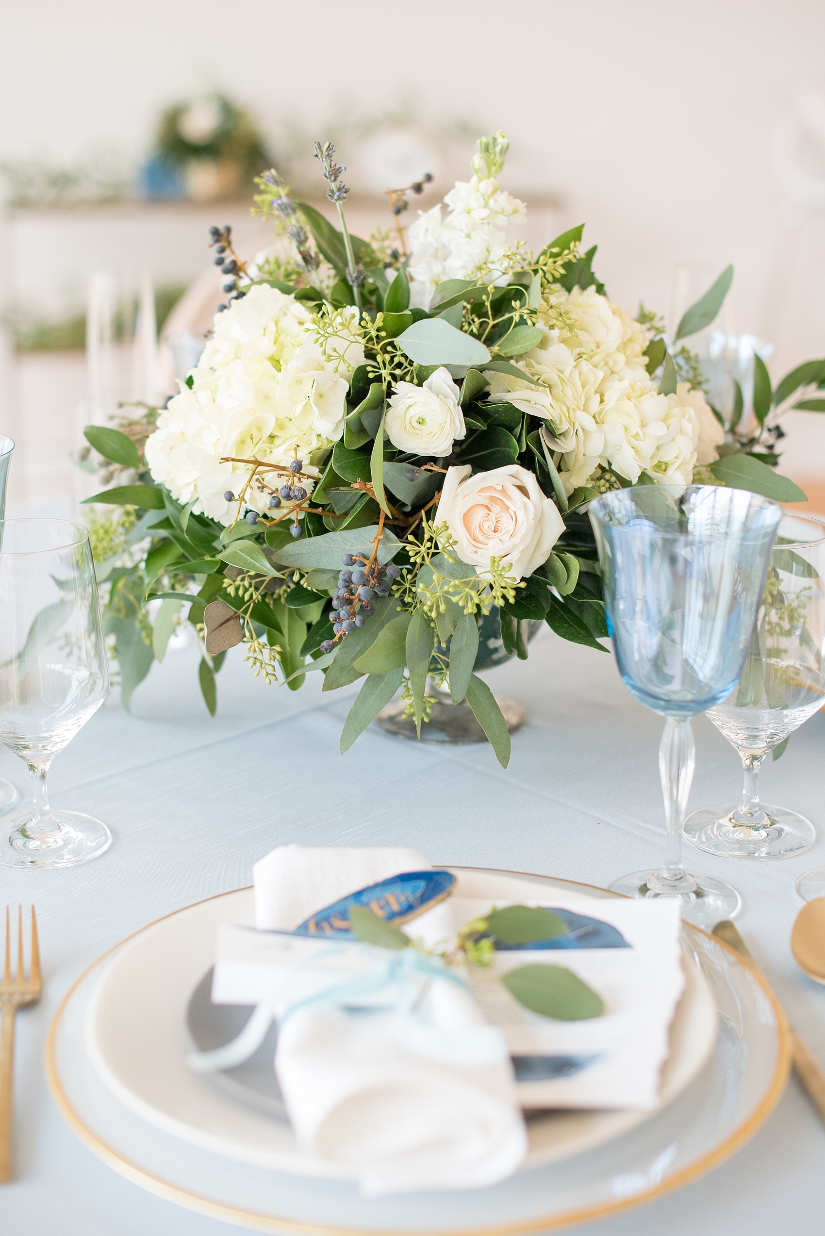 The Glass Box Raleigh wedding photos by Mikkel Paige Photography. Picture of a blue and white table with grey and gold place settings in this modern downtown venue.