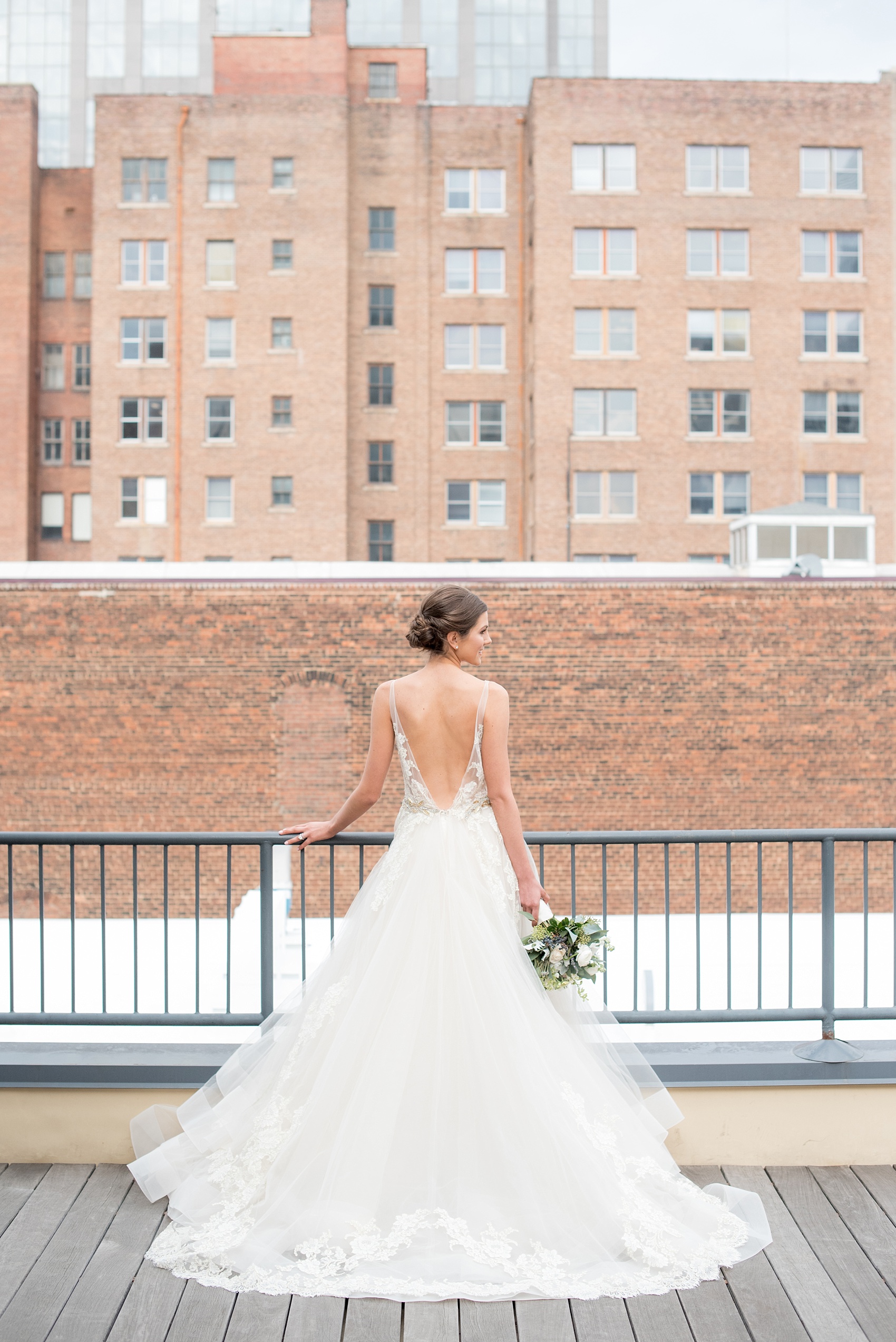 The Glass Box Raleigh wedding photos by Mikkel Paige Photography. Picture of the bride in a Lazaro gown in this modern downtown venue rooftop.