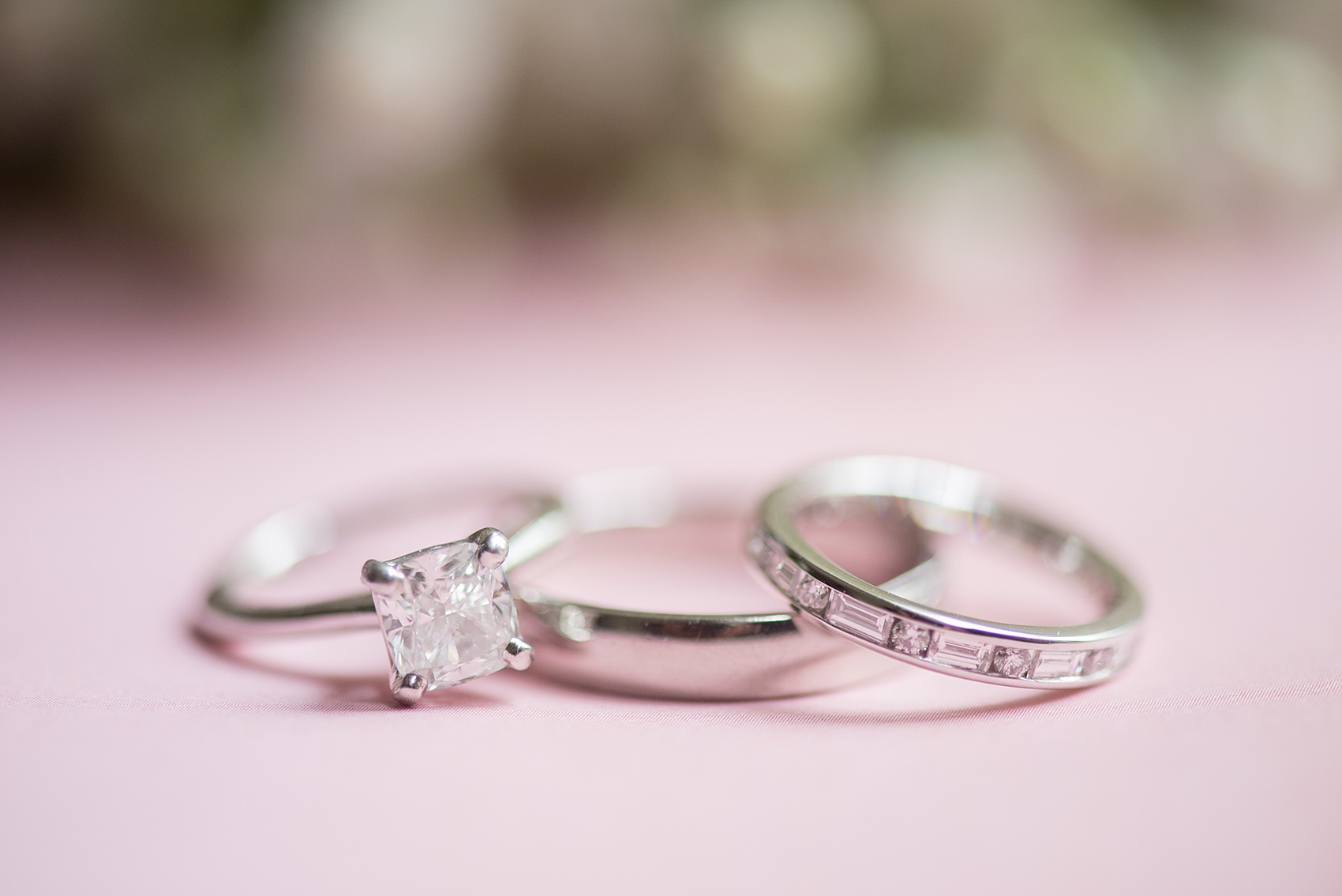 Waveny House wedding photos in Connecticut by Mikkel Paige Photography. Detail picture of the couple's diamond wedding rings against a pink background.