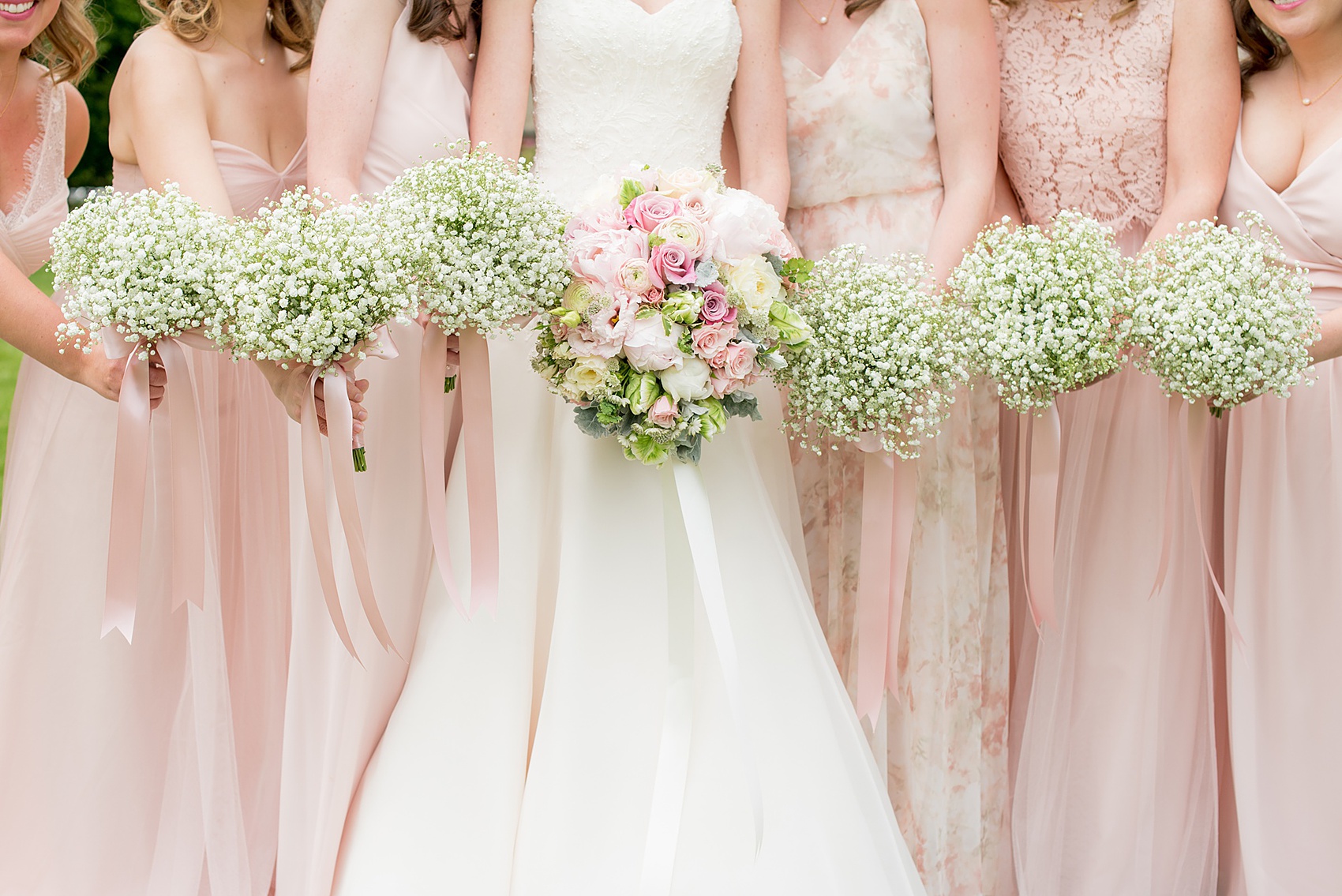 Waveny House wedding photos in Connecticut by Mikkel Paige Photography. Picture of the bride in a strapless gown with her bridesmaids in pink dresses, and maid of honor in a pink floral pattern gown. Bridesmaids held Baby's Breath bouquets.